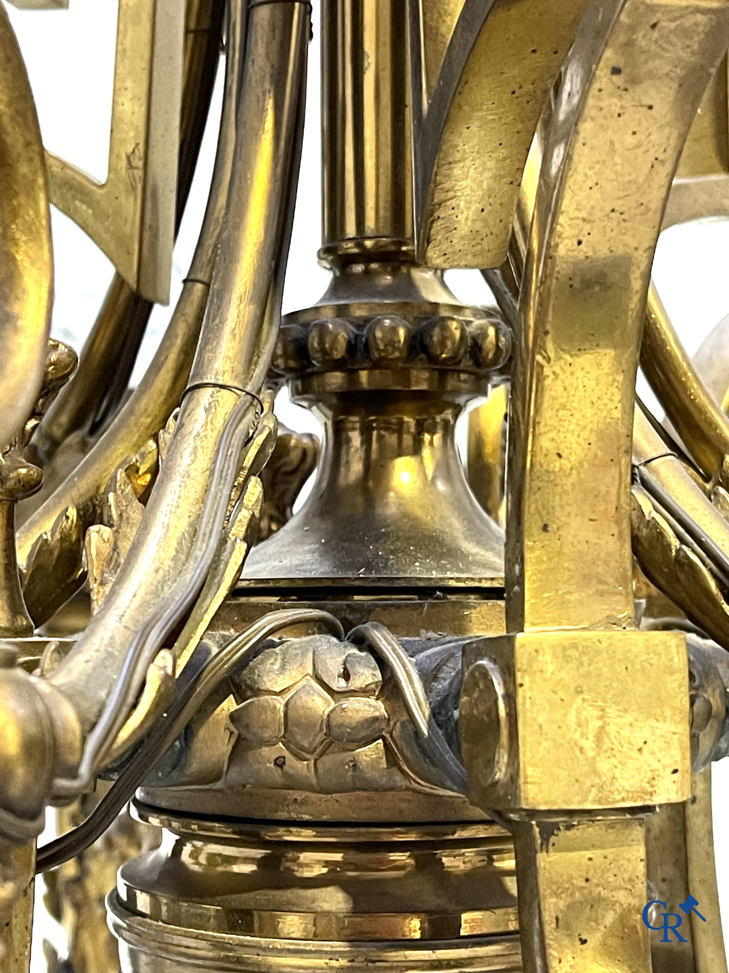 A lot of an imposing chandelier with 12 light points, a lamp belge with bronze frame and a fireplace piece.