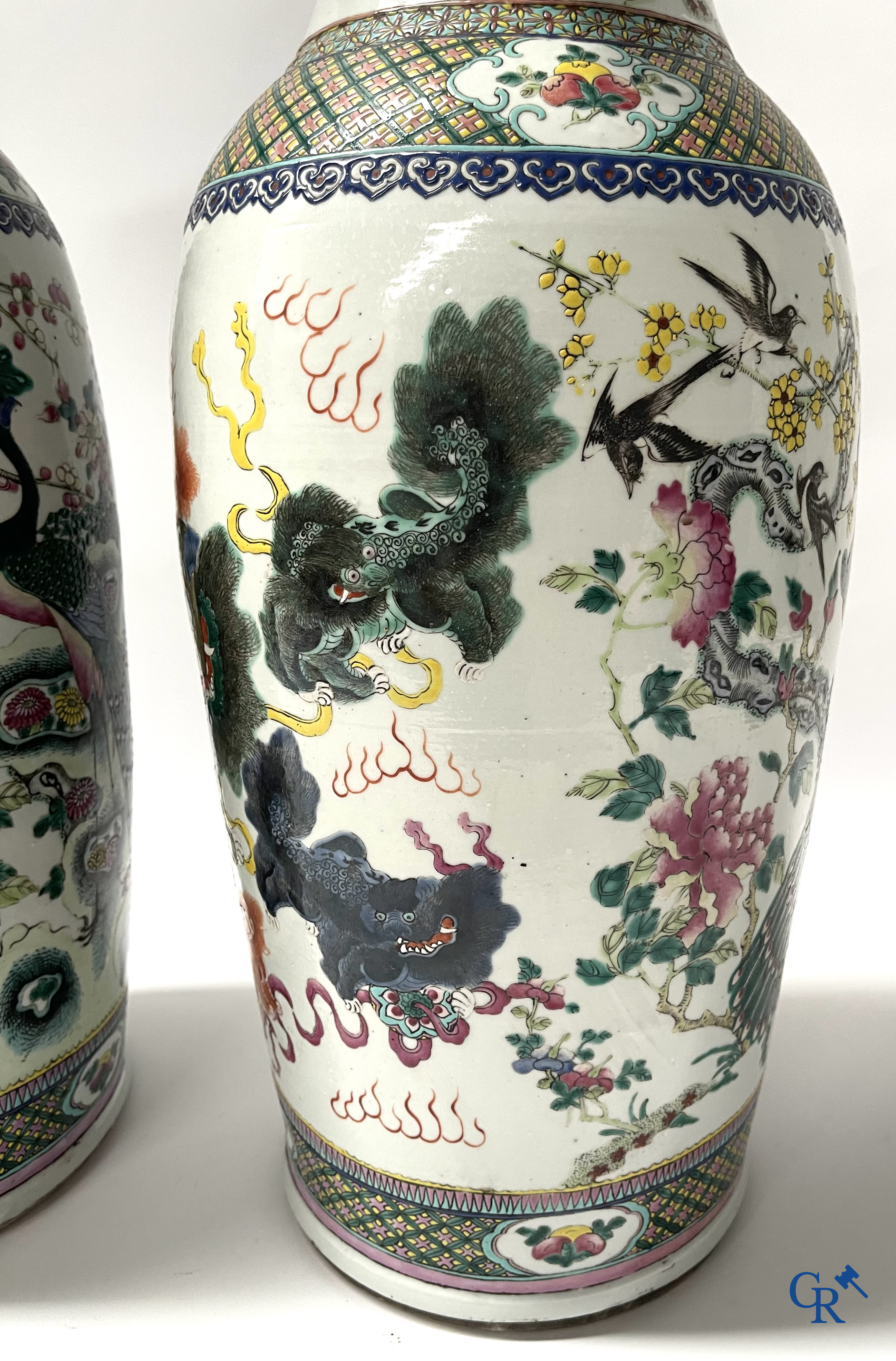 Asian Art, A pair of Chinese famille rose vases with peacocks and Fo dogs. 19th century.