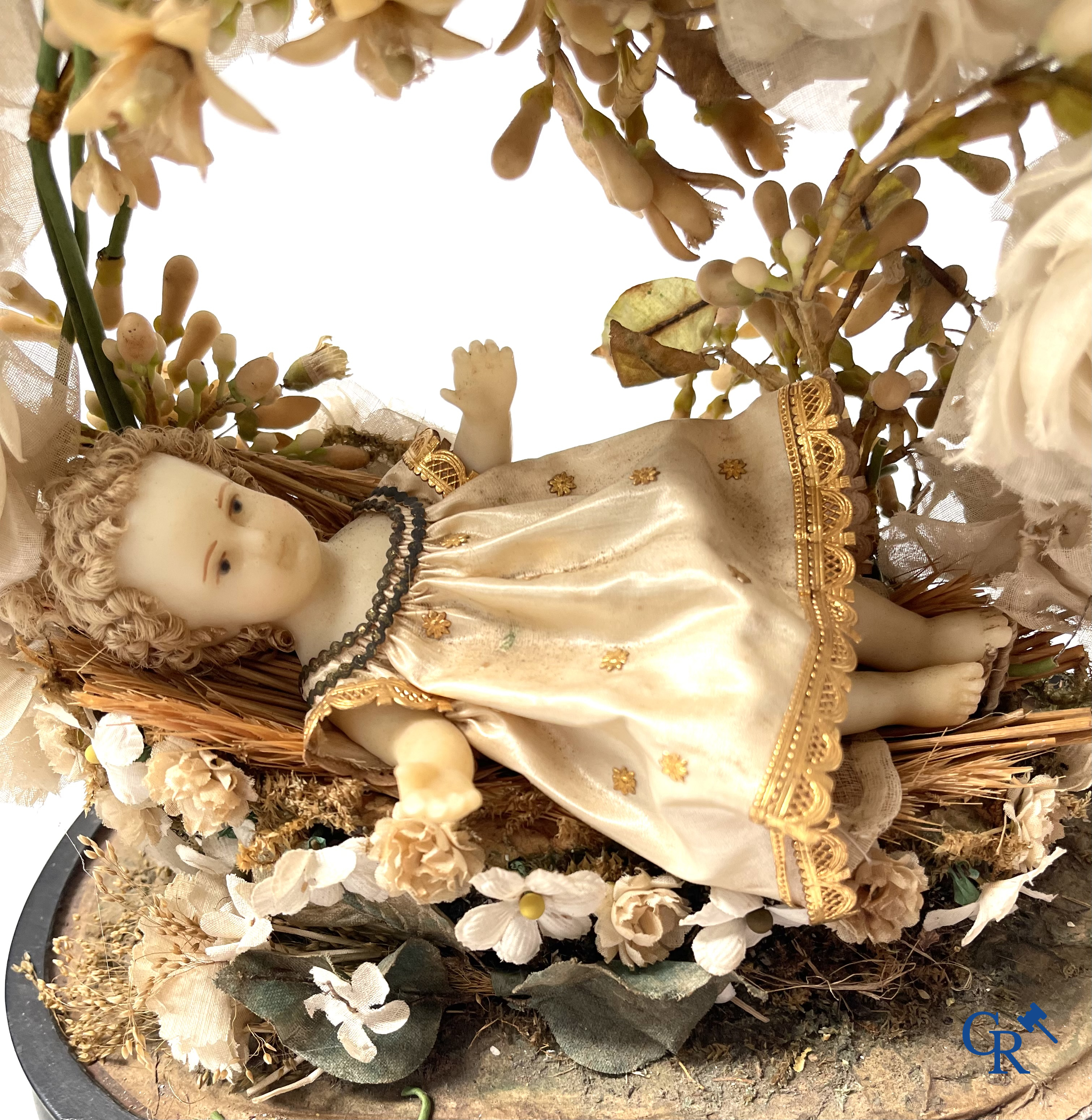 A globe in glass with a child in wax and a brass display case with bridal bouquet. Around 1900.