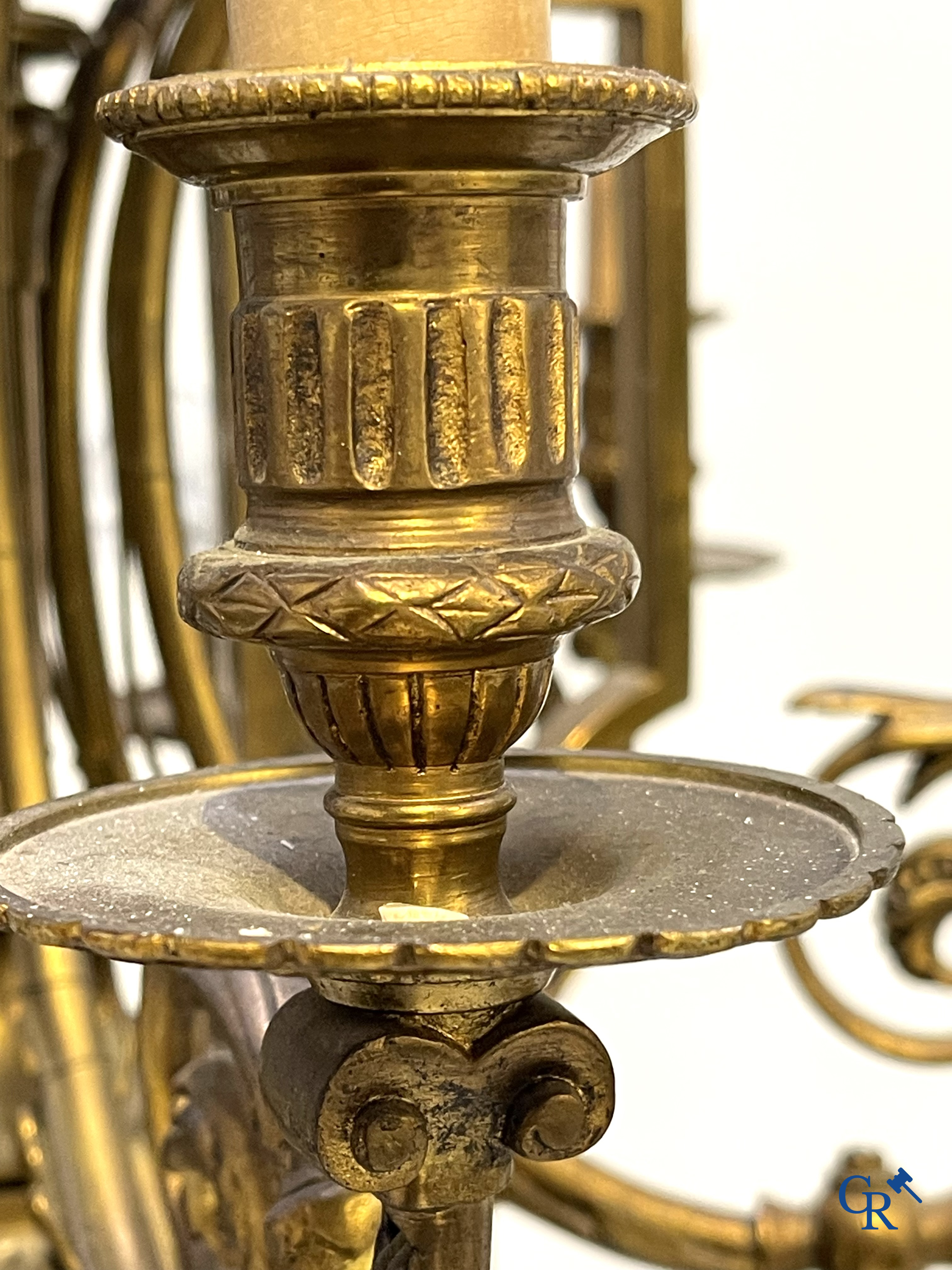 A lot of an imposing chandelier with 12 light points, a lamp belge with bronze frame and a fireplace piece.