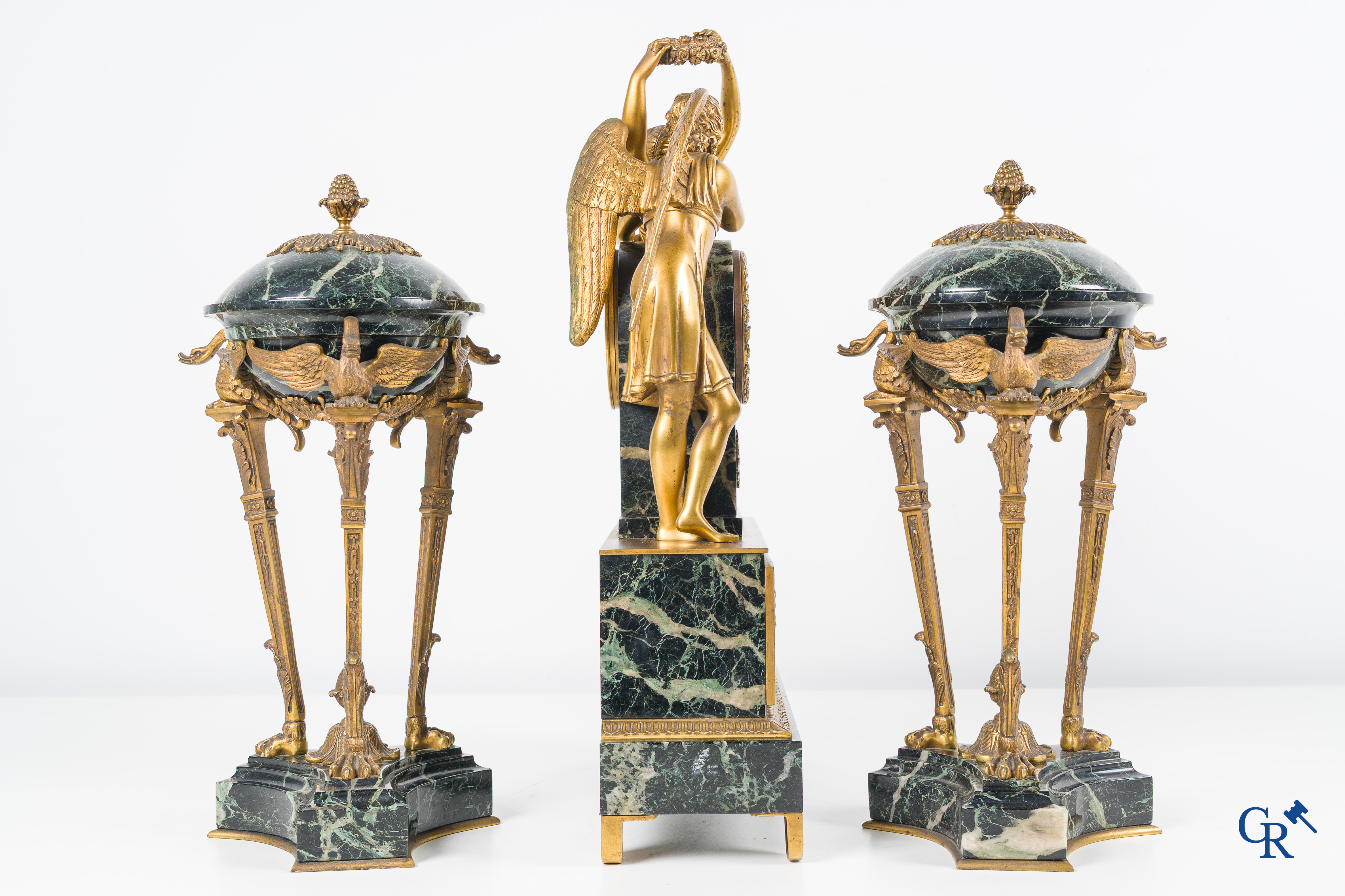 Een 3-delige schouwgarnituur in groen geaderde marmer en vergulde brons. Empire stijl. Circa 1900.