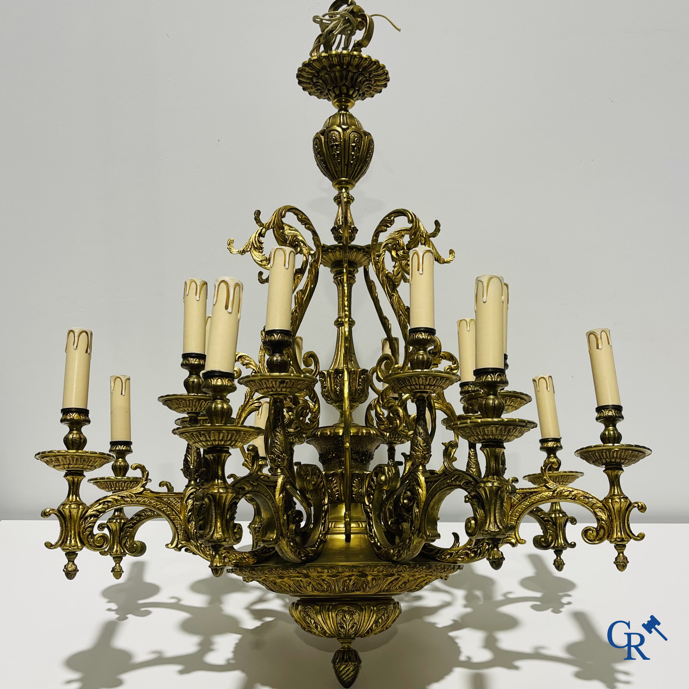 Un grand lustre en bronze avec 16 points lumineux et une applique murale assortie.