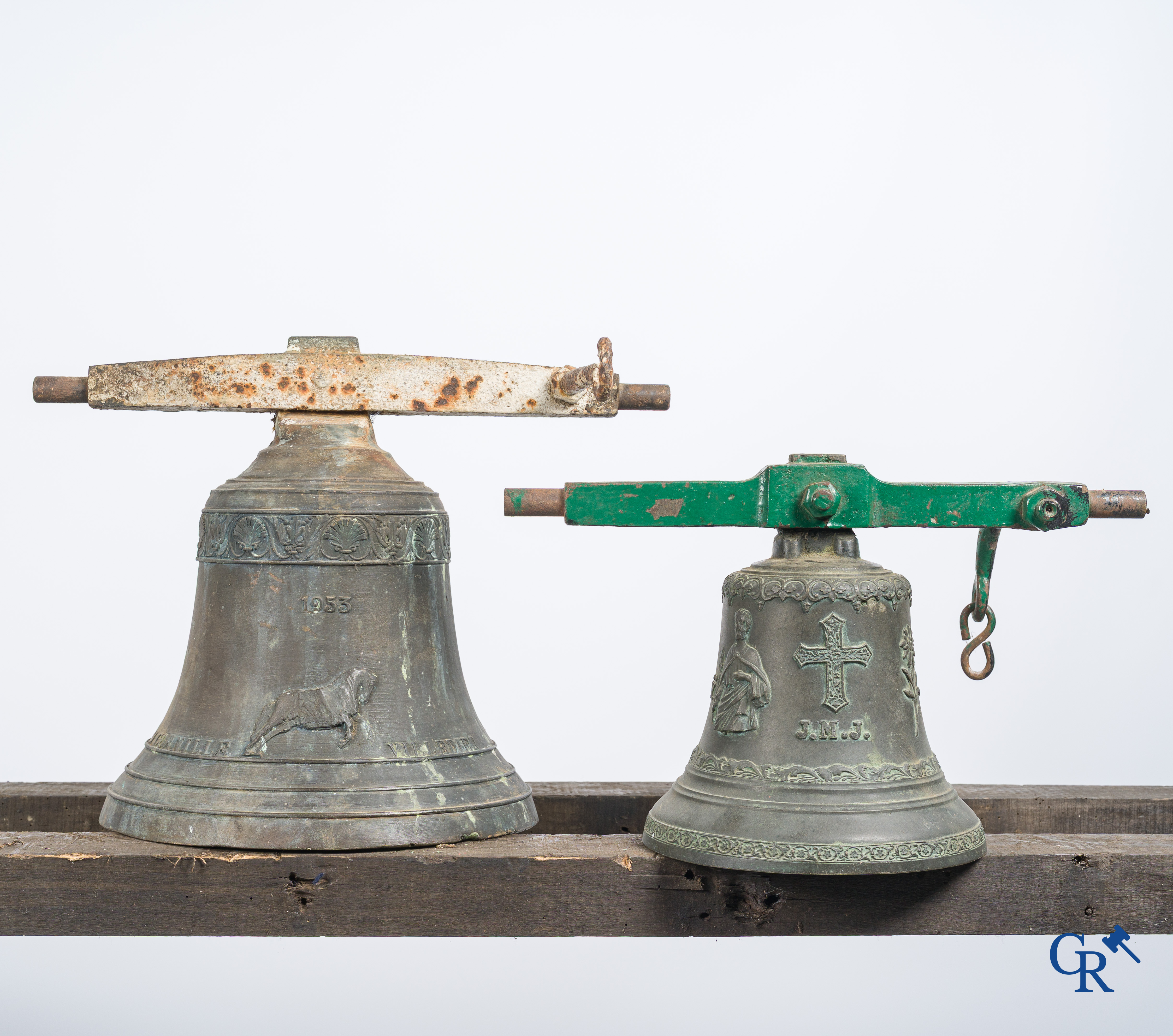 2 Bronzen bellen met smeedijzer juk, waarvan één met een gedecoreerde inscripitieband en afbeelding van een paard.