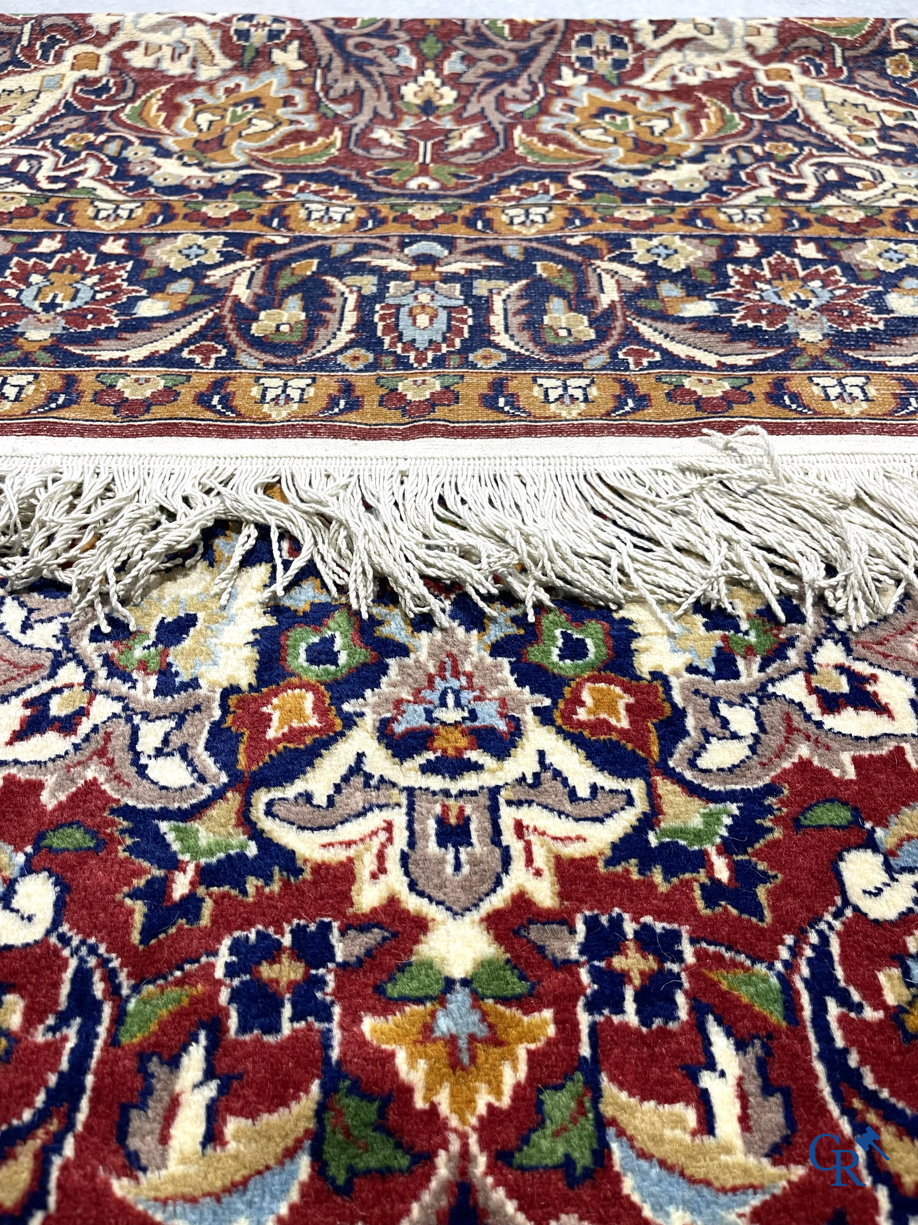 Oriental carpets. Finely hand-knotted carpet with floral decor on a dark red background.