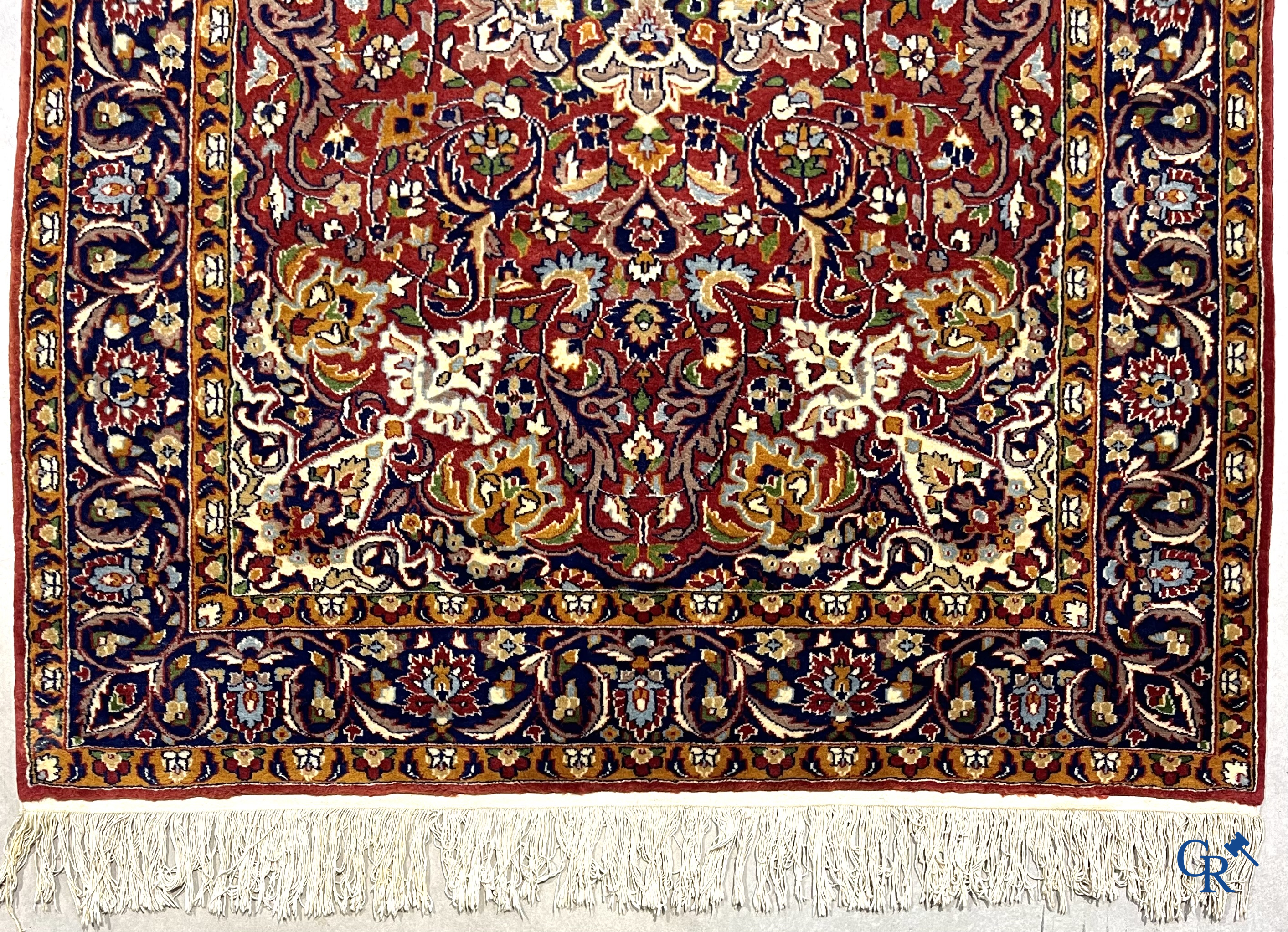 Oriental carpets. Finely hand-knotted carpet with floral decor on a dark red background.