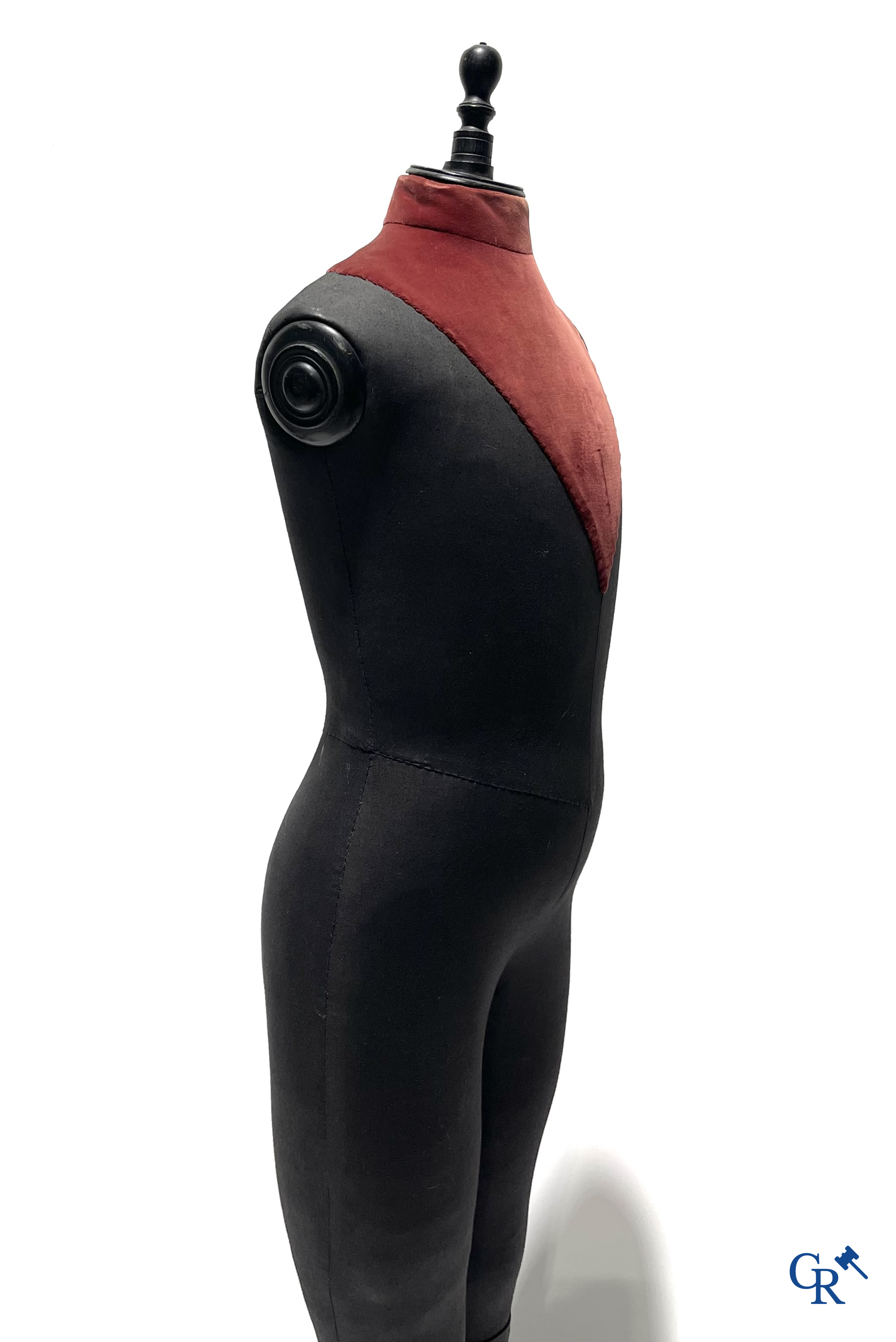 Een kindermannequin met houten laarzen en zwarte stof in de stijl van Stockman. Circa 1900.