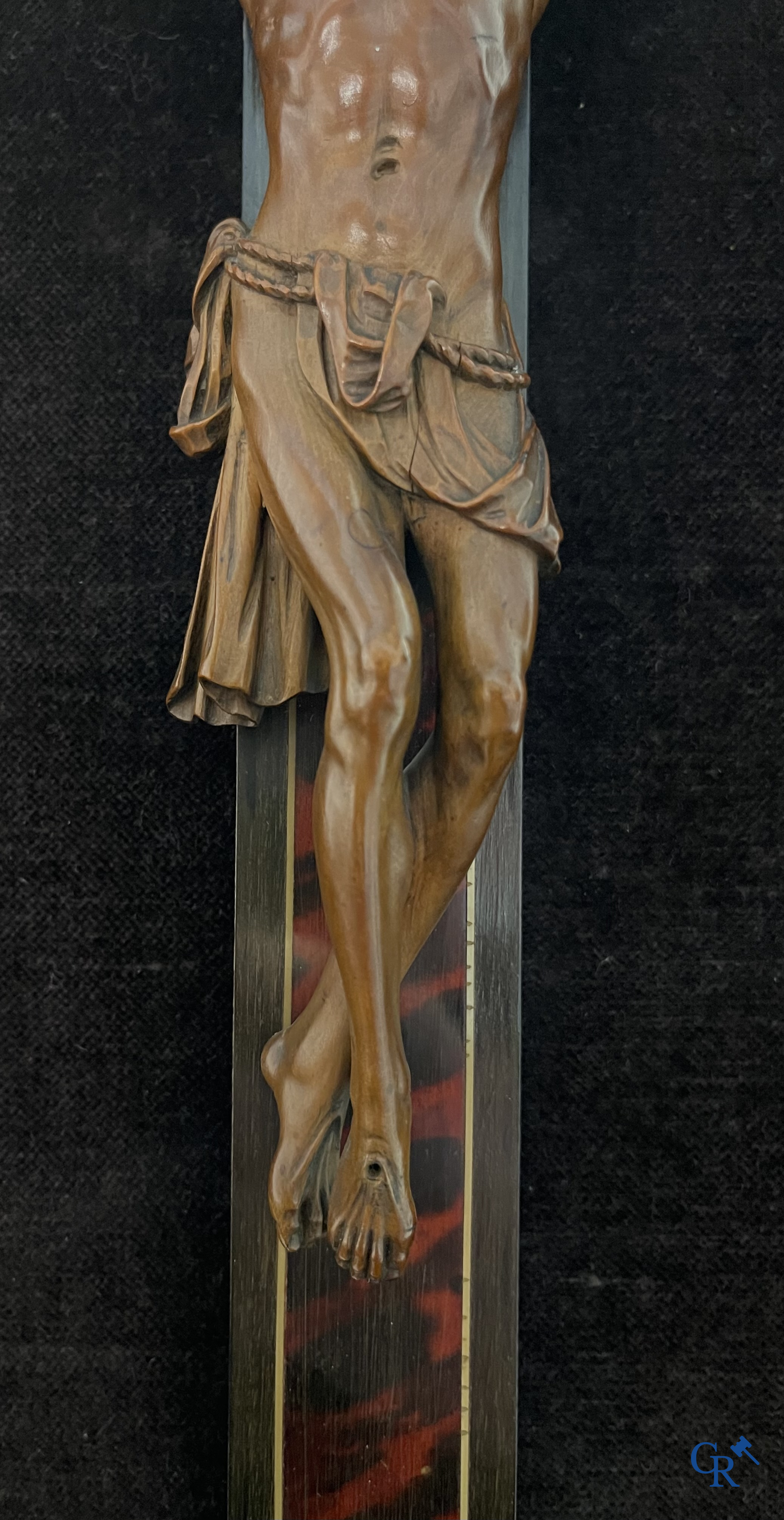 Corpus Christi in fijngesneden palmhout gemonteerd op kruis. Kader van de werkhuizen Franck te Antwerpen. 18e-19e eeuw.