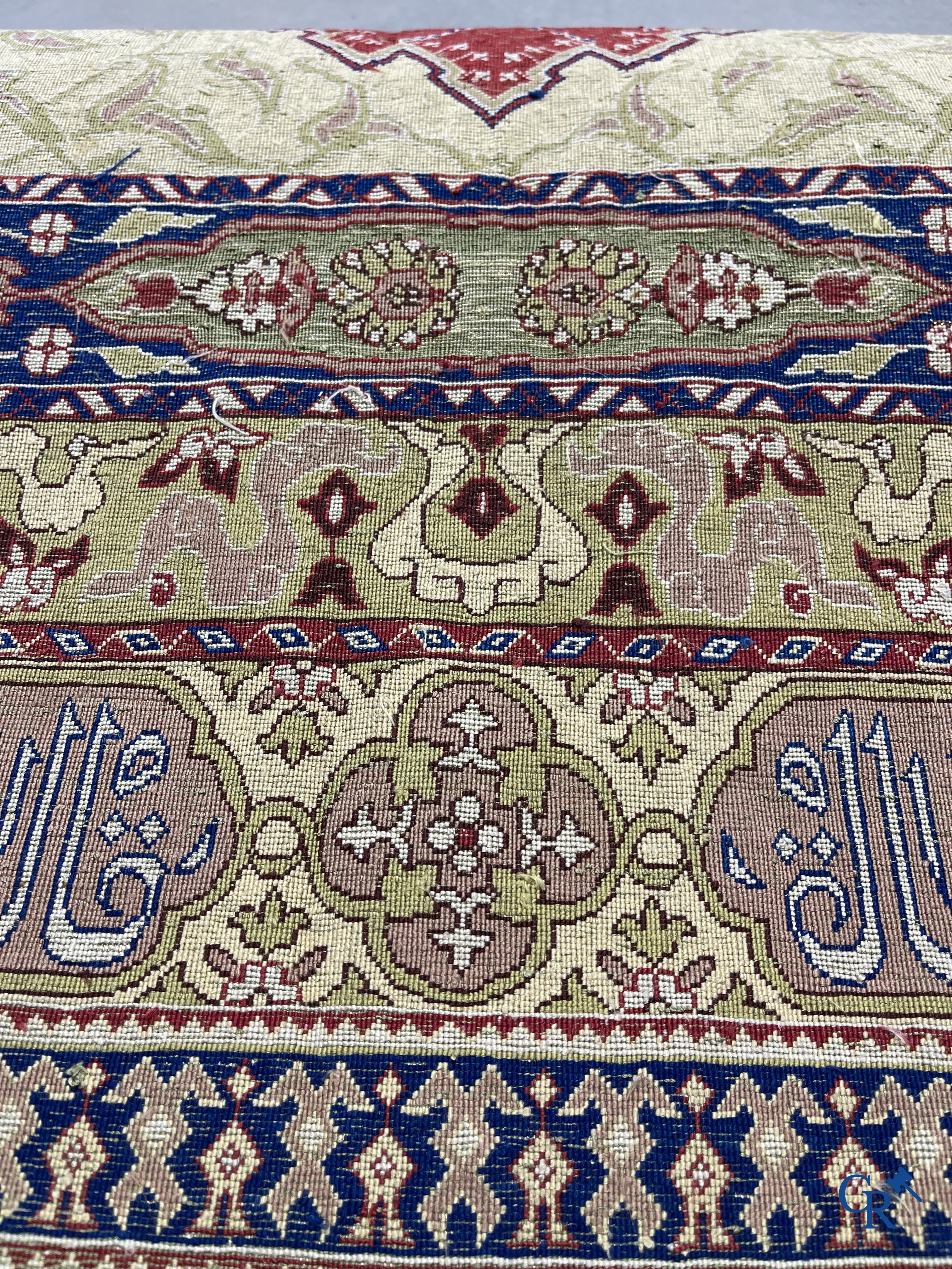 Oosterse tapijten. Een uiterst fijn handgeknoopt zijden tapijt met inscripties en gouddraad. Gesigneerd.