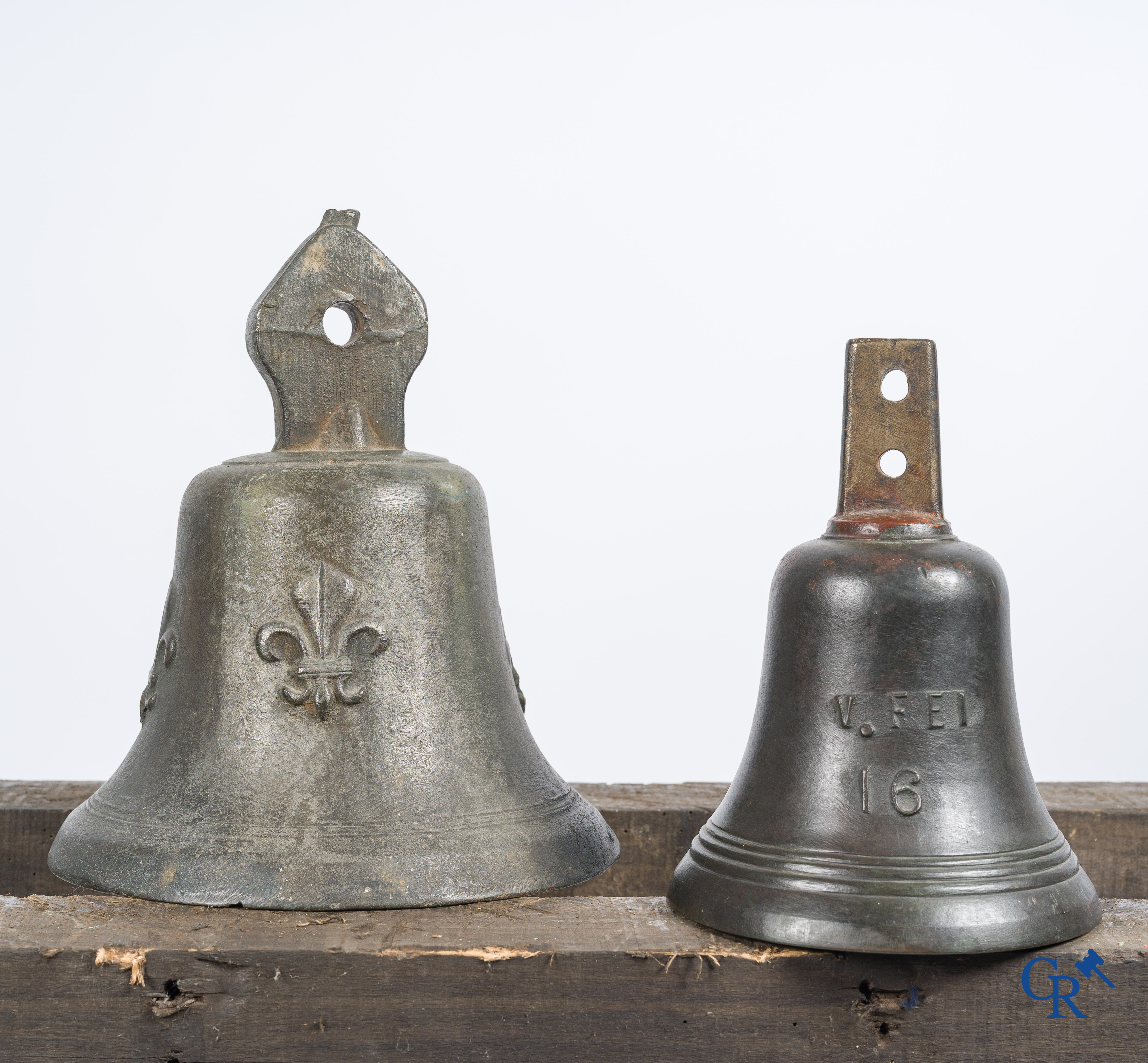 2 antique bronze bells. One decorated with "fleurs de lys" and Christ, the other decorated with an angel.