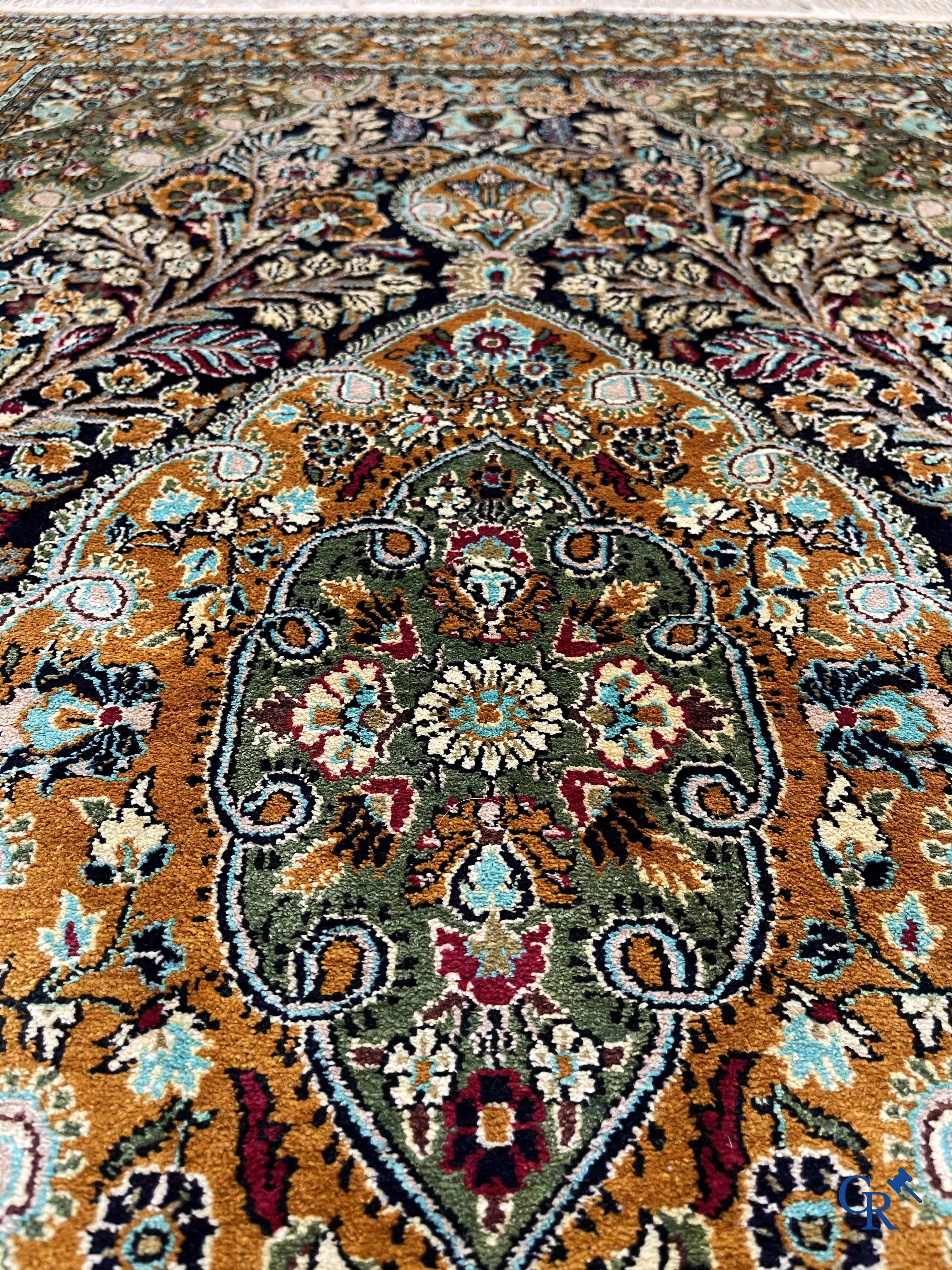 Oriental carpets. Hand-knotted silk carpet with floral decor on an orange background.