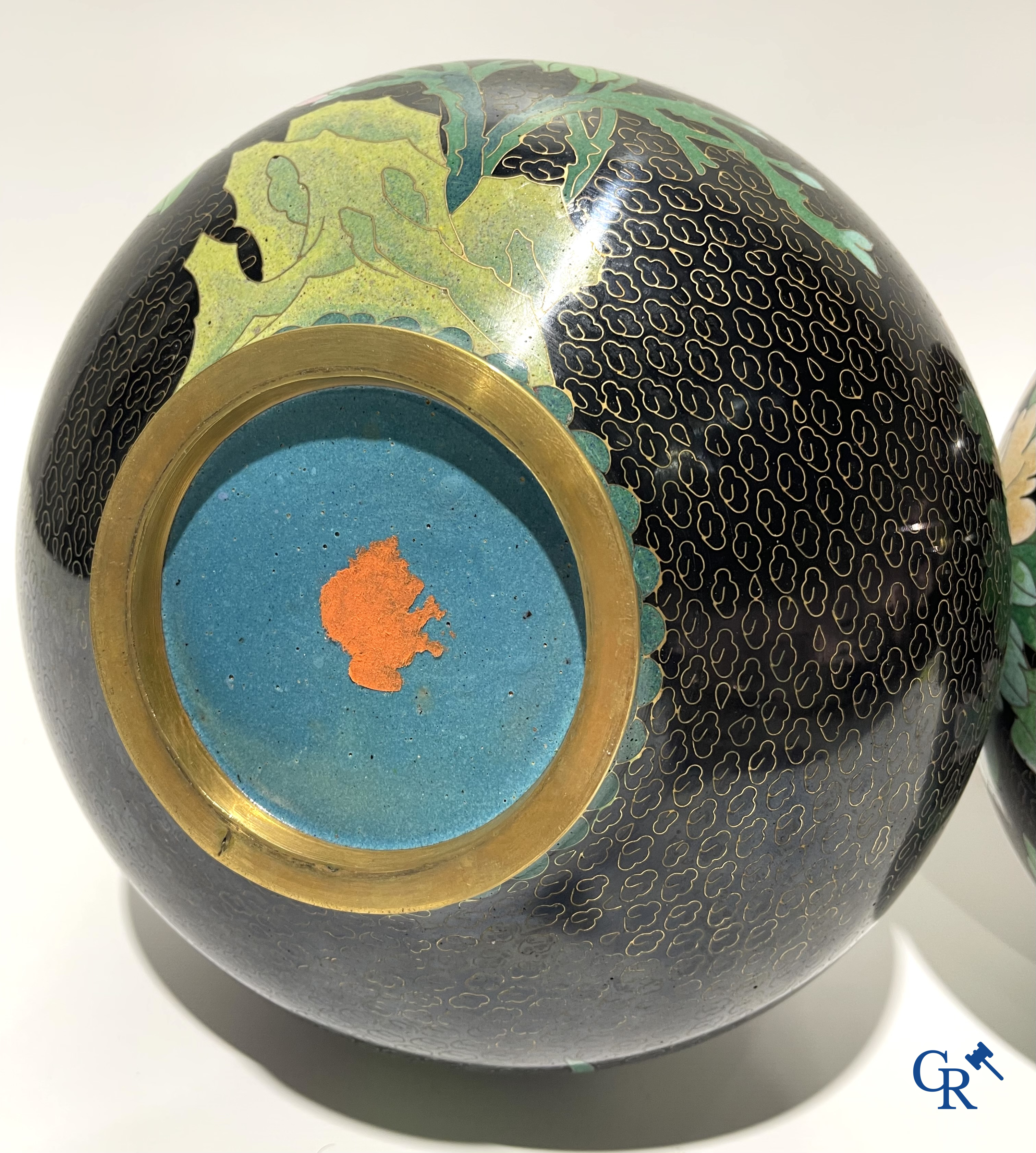 A pair of Chinese cloisonne vases with floral decor.