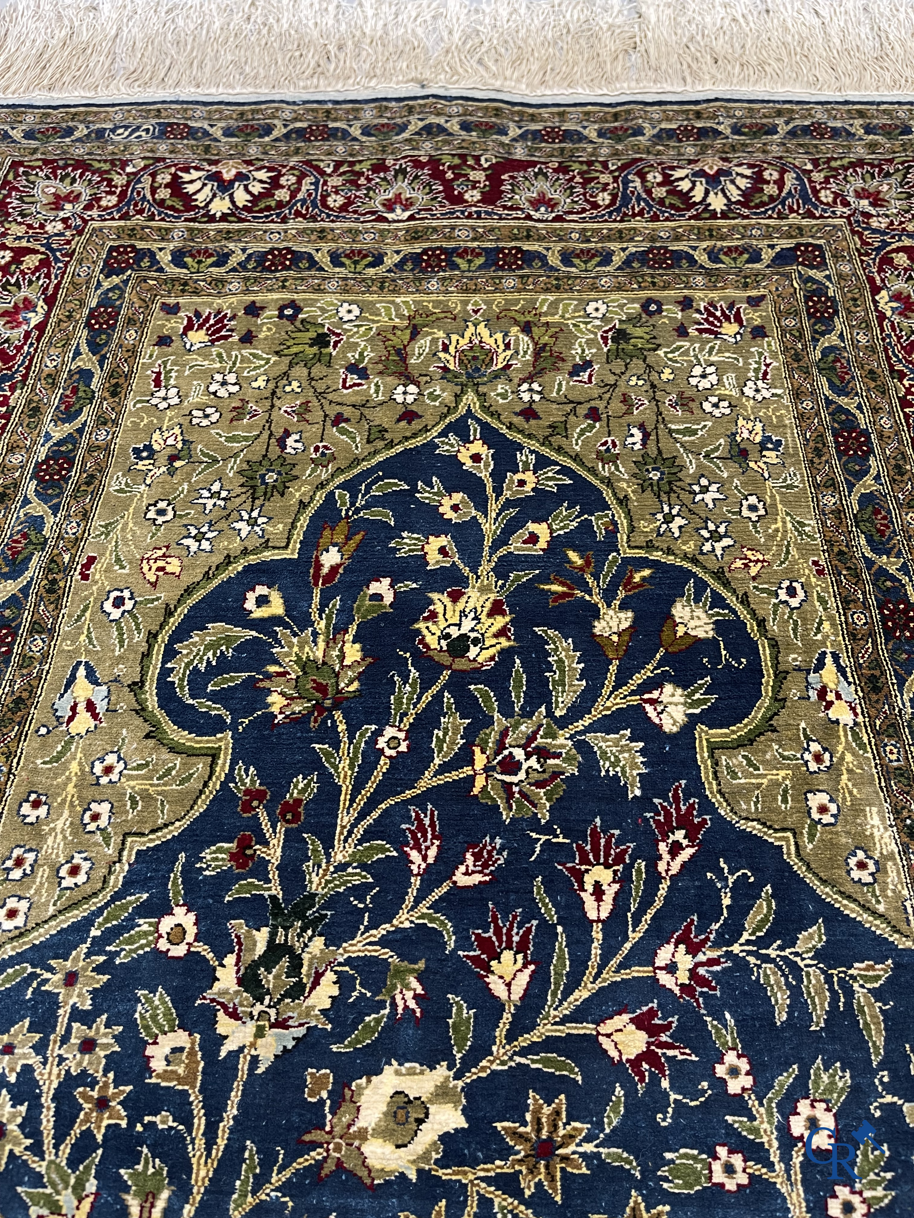 Oosterse tapijten. Een uiterst fijn geknoopt zijden tapijt met floraal decor op donker blauwe achtergrond en gouddraad.