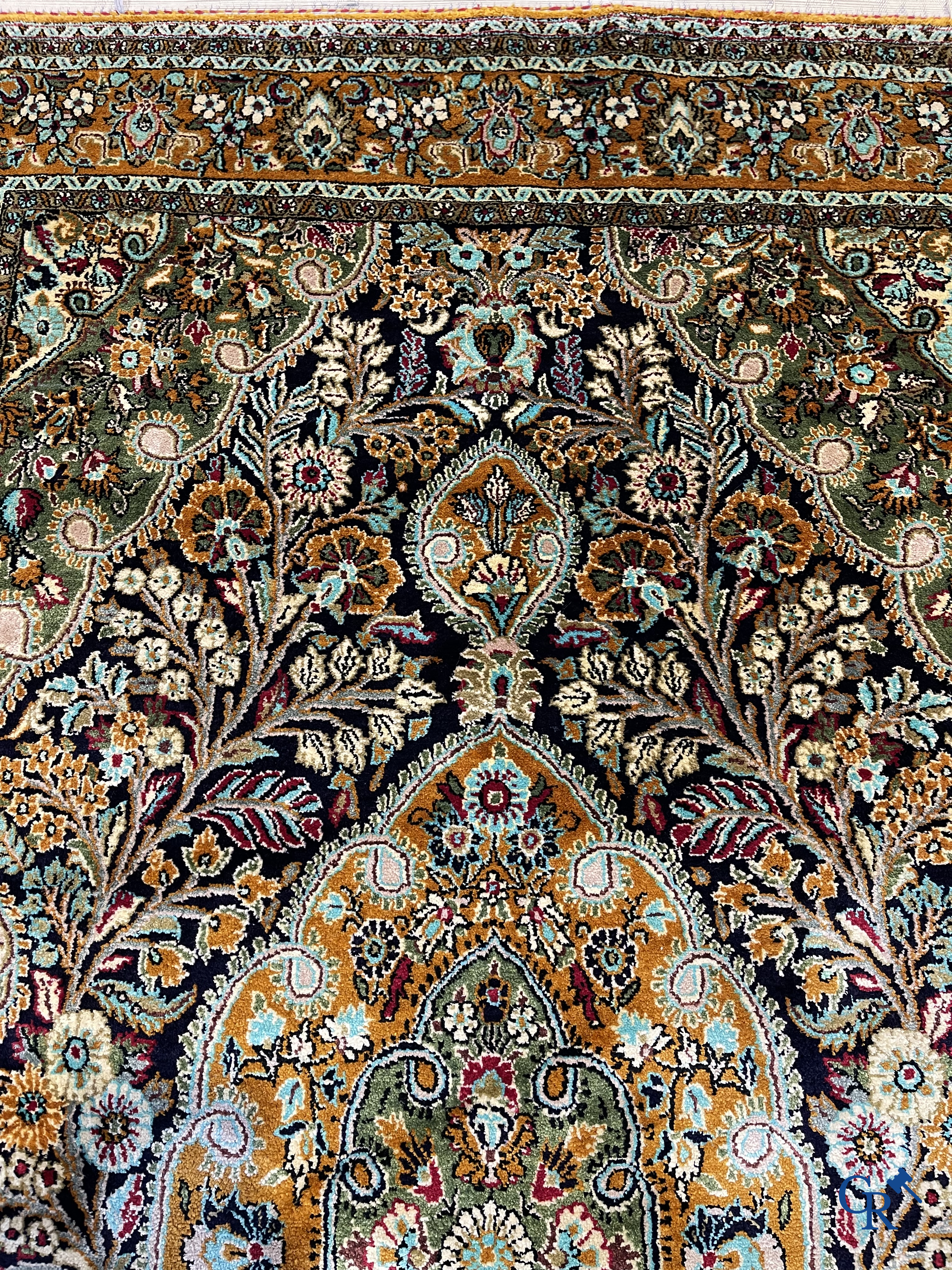 Oriental carpets. Hand-knotted silk carpet with floral decor on an orange background.