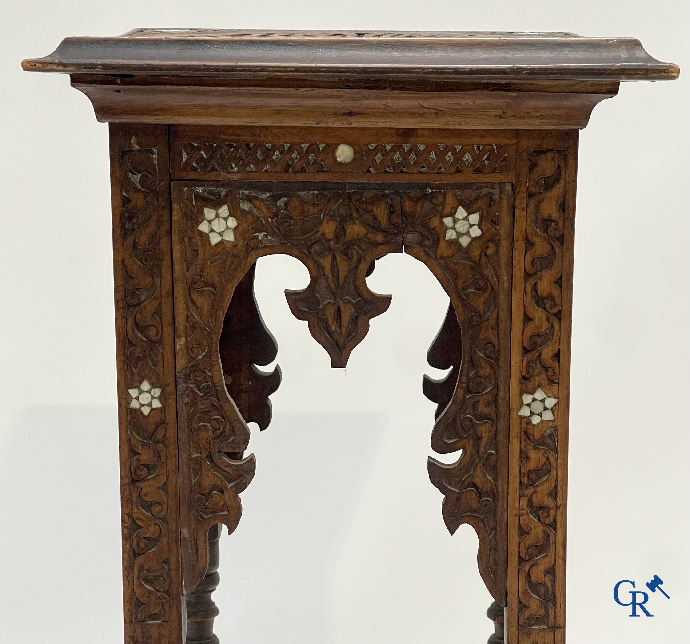 Een hout gesculpteerde sokkel in Oosterse stijl met parelmoer inlegwerk. Circa 1900.