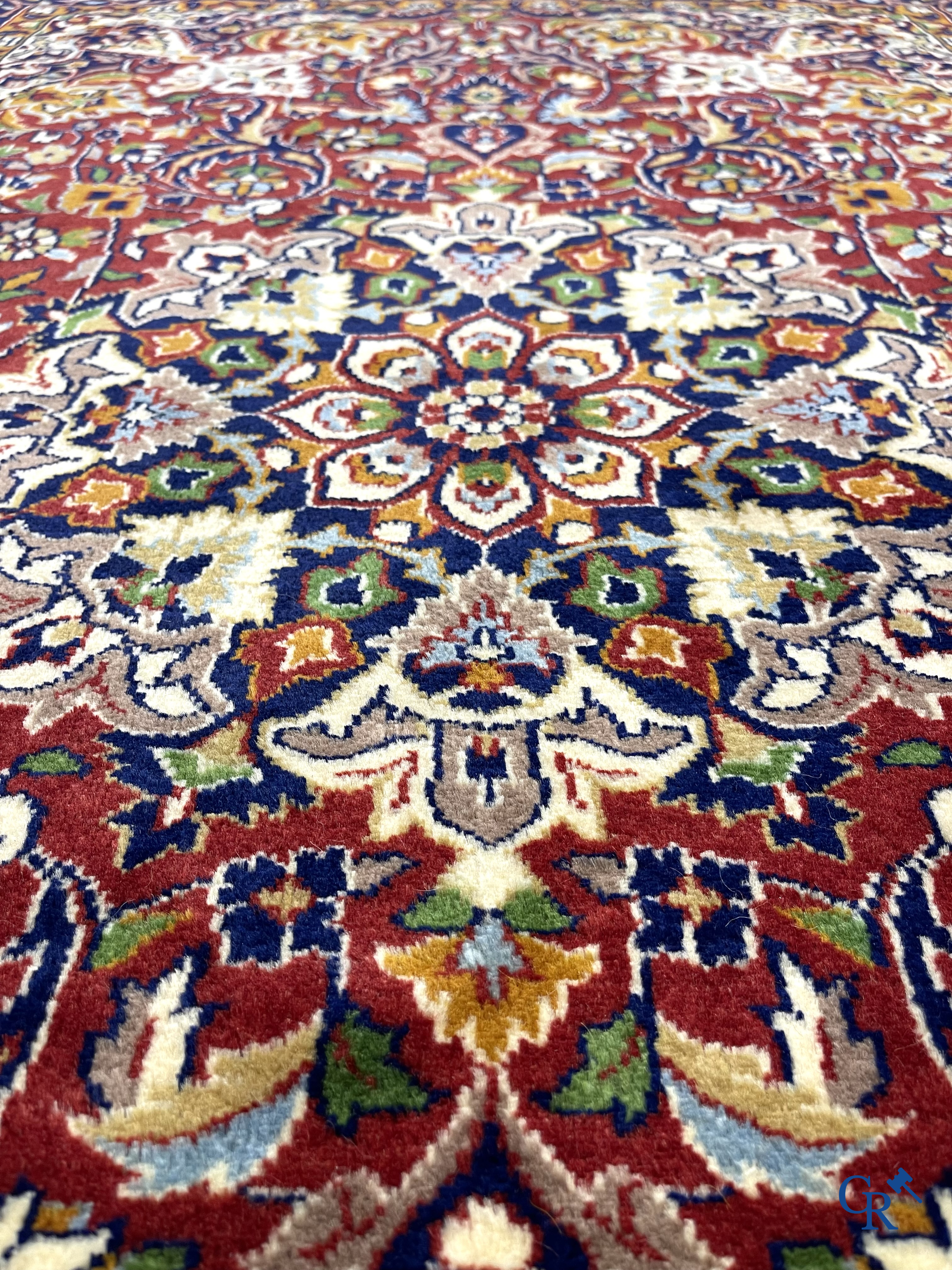 Oriental carpets. Finely hand-knotted carpet with floral decor on a dark red background.