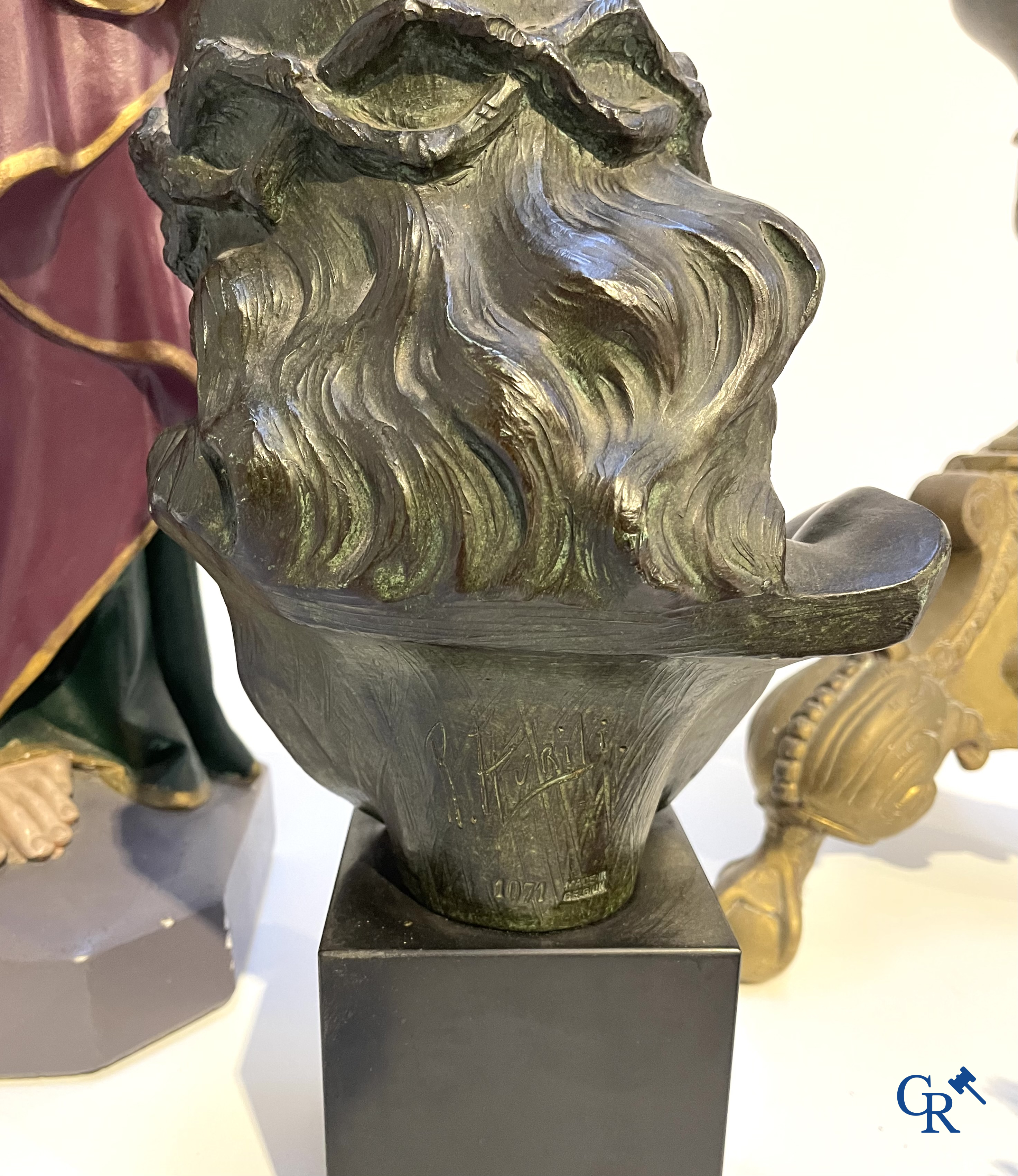 Een grote bronzen kandelaar, Sint Jozef met kind in plaaster, een terracotta buste van Christus en een wijwatervat.