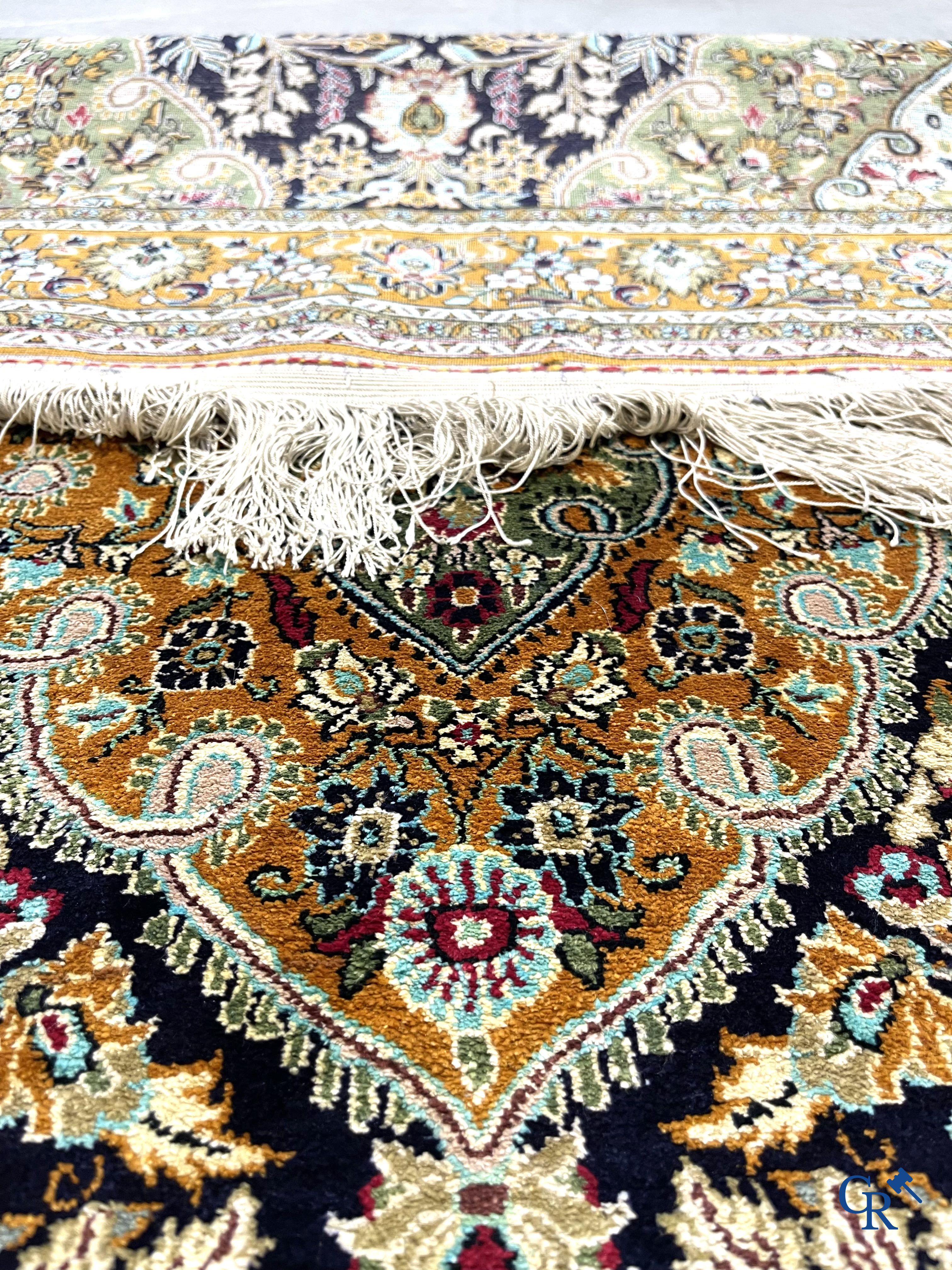 Oriental carpets. Hand-knotted silk carpet with floral decor on an orange background.
