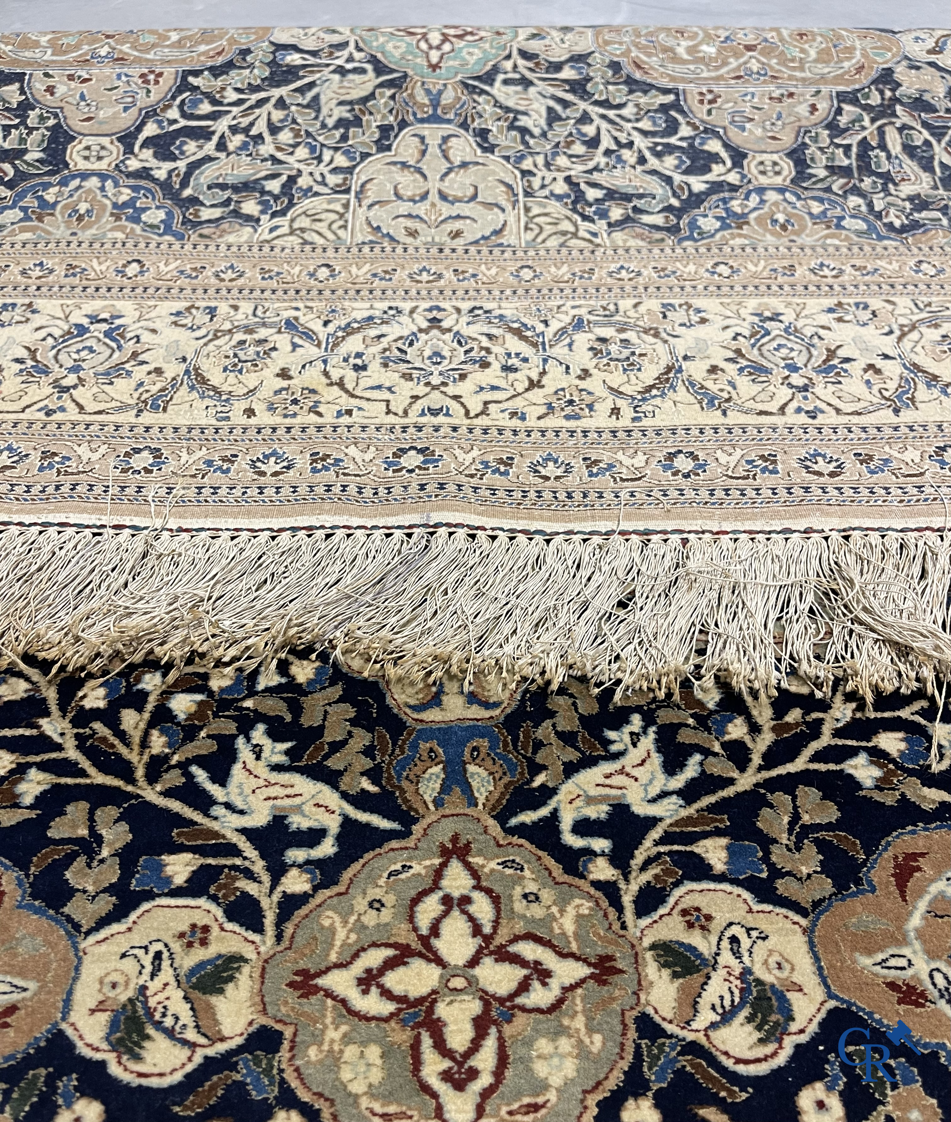 Oosterse tapijten. Een handgeknoopt tapijt met wouddieren en bloemen.