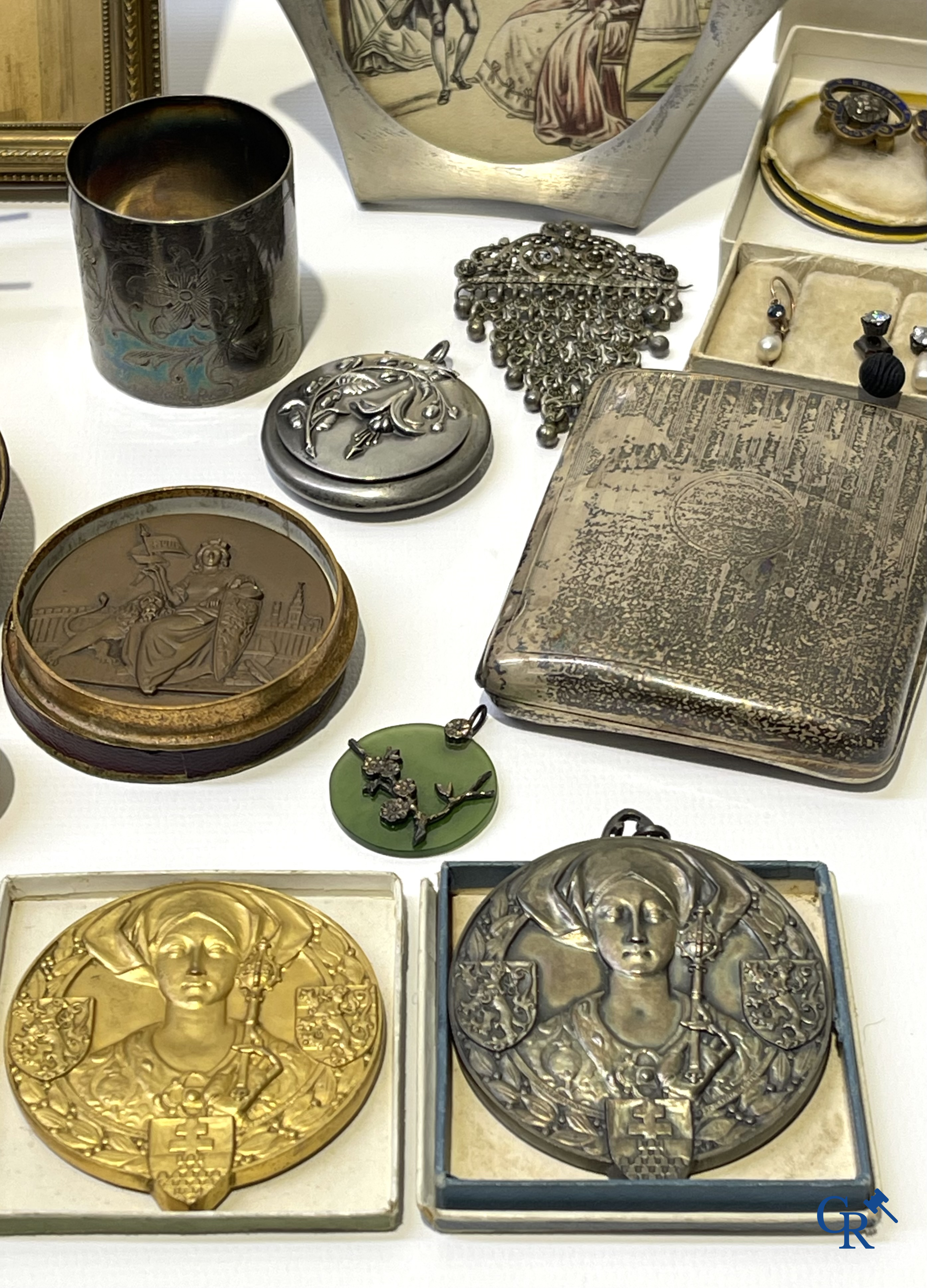 Een uitgebreid lot met vitrineobjecten. Zakhorloges, miniaturen, bronzen kaders, fantasiejuwelen enz. Sommige in zilver.