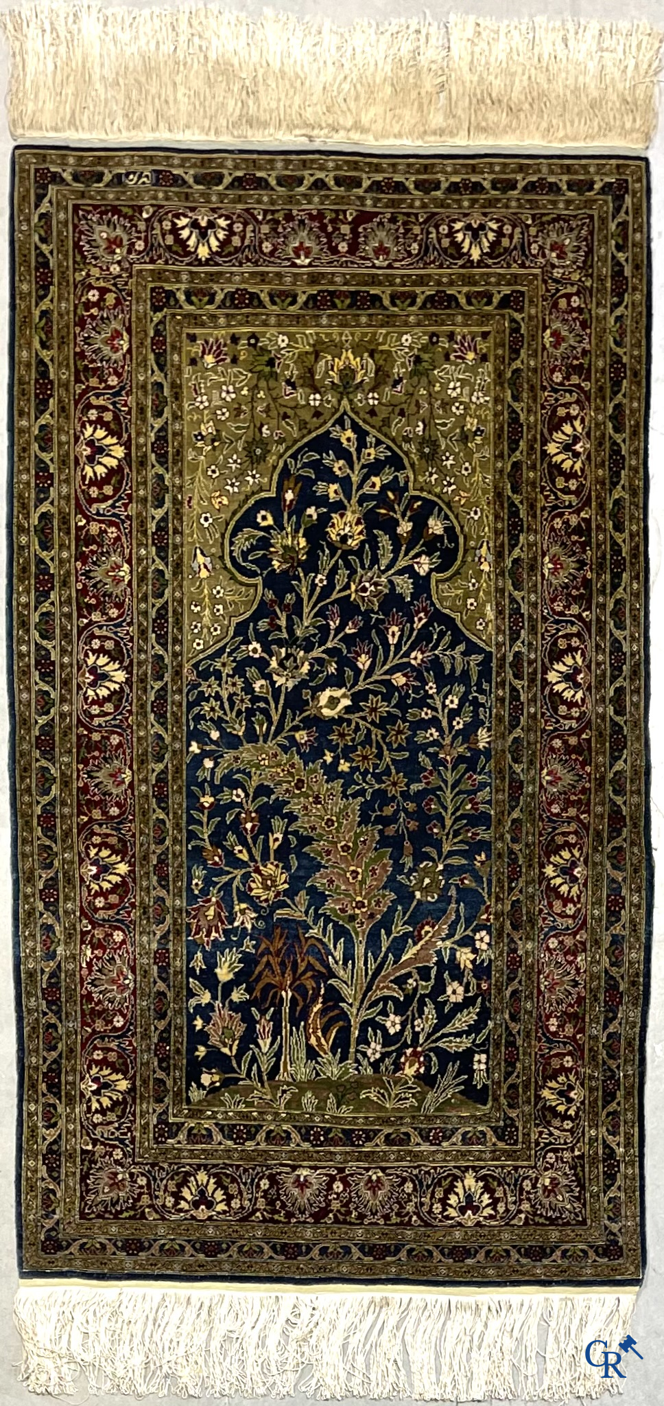 Oosterse tapijten. Een uiterst fijn geknoopt zijden tapijt met floraal decor op donker blauwe achtergrond en gouddraad.