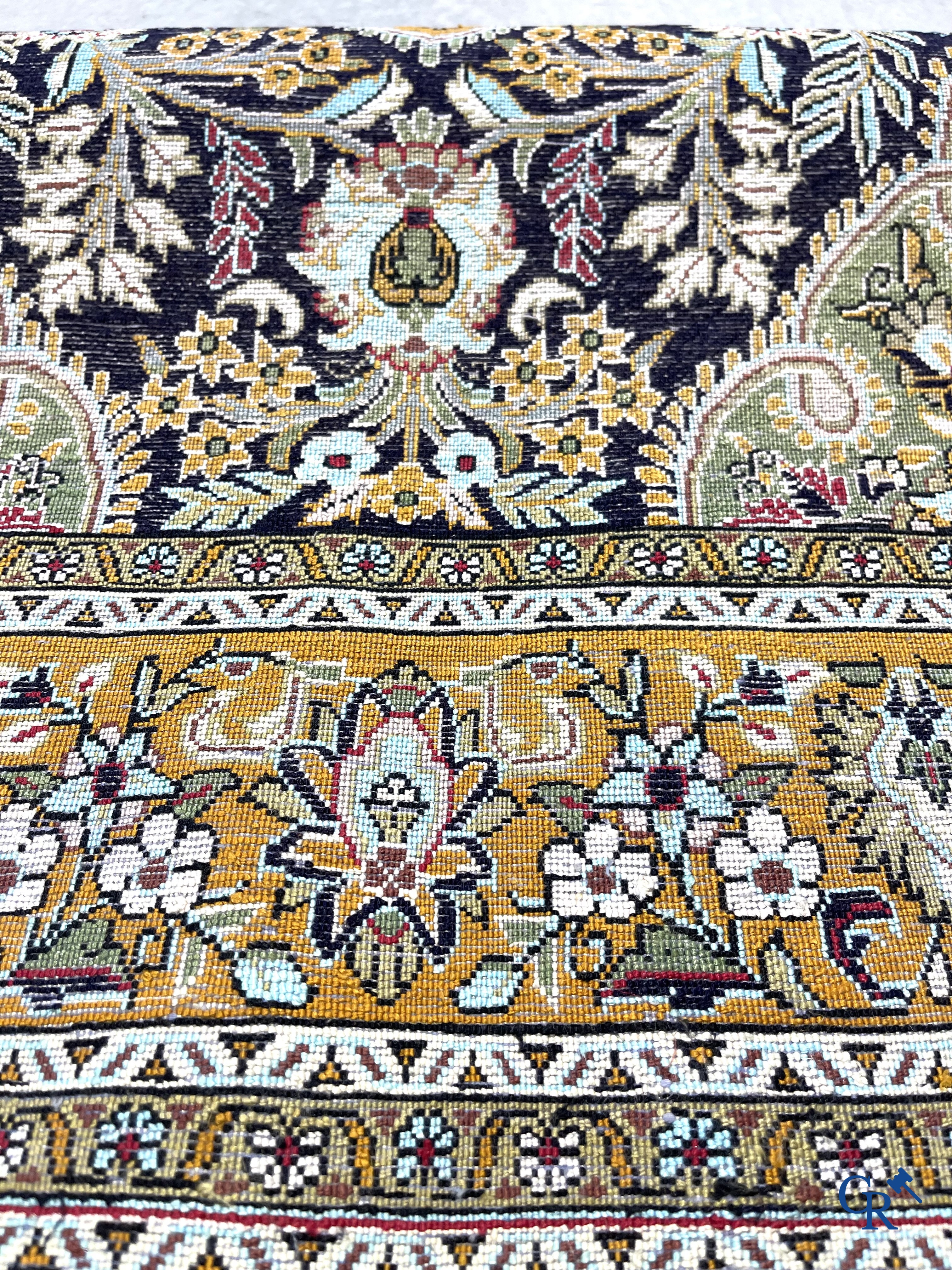 Oriental carpets. Hand-knotted silk carpet with floral decor on an orange background.