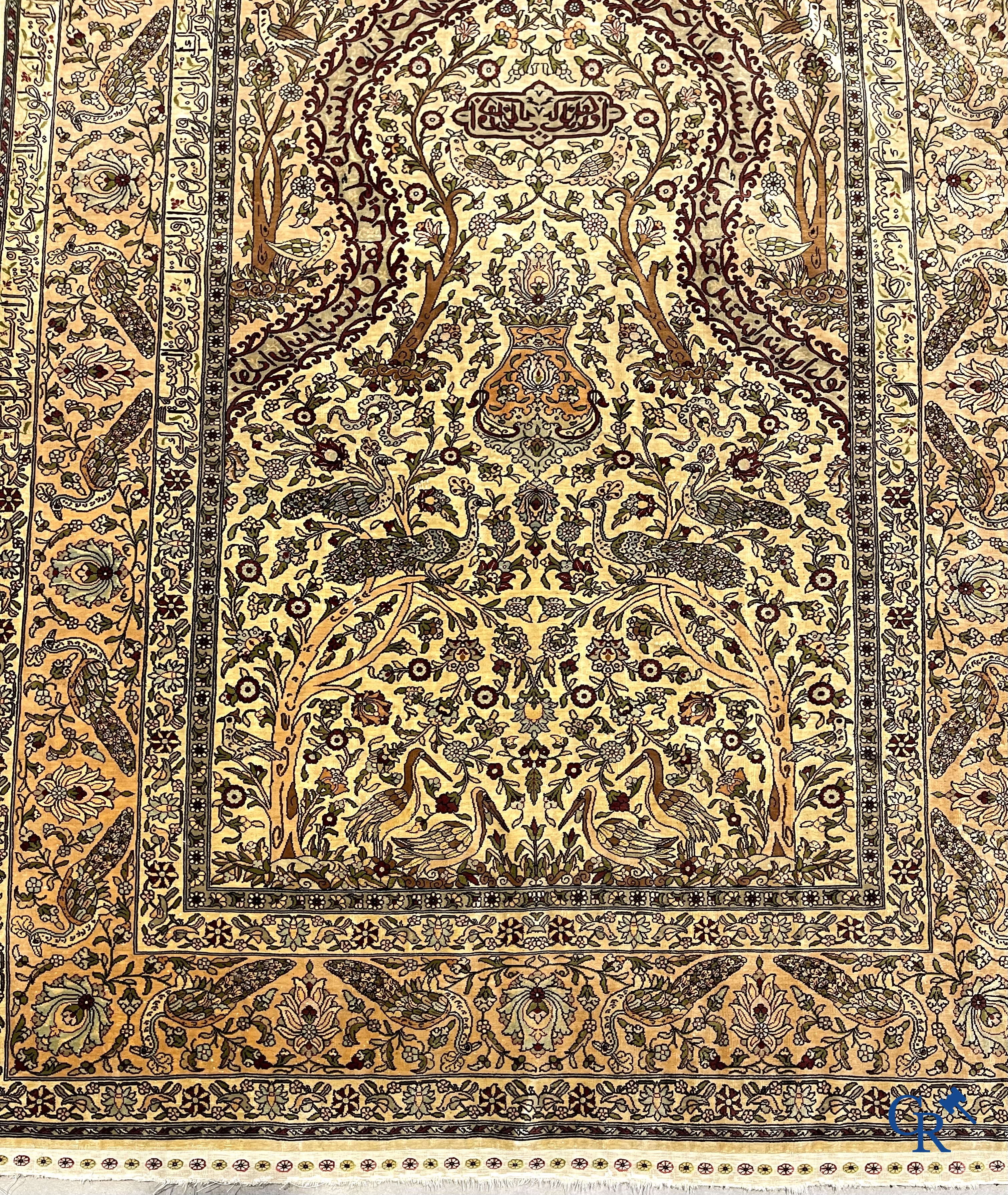 Oriental carpets. Hereke. A finely hand-knotted silk carpet with birds in the forest. Inscriptions and signed.