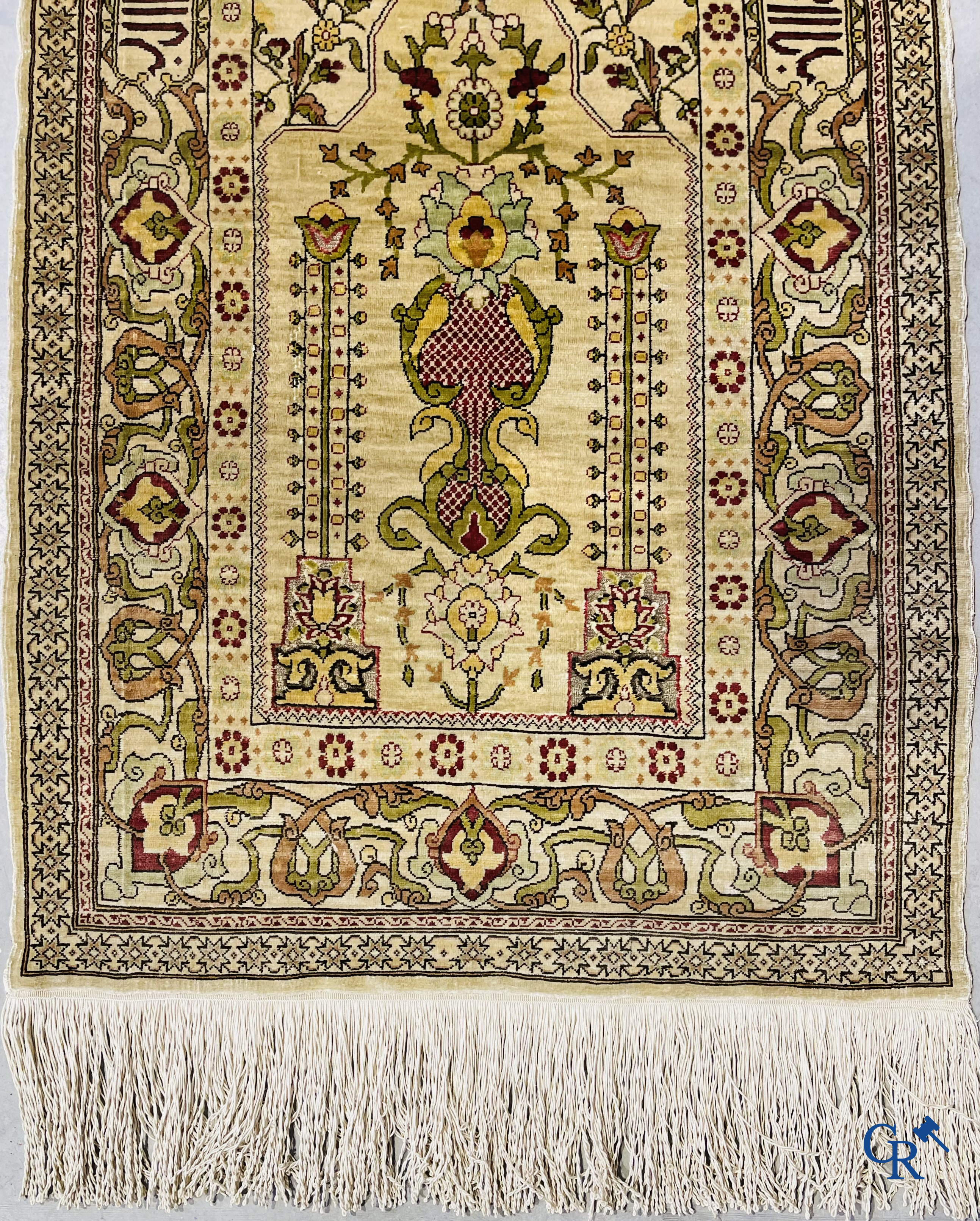 Oosterse tapijten. Hereke, een zijden tapijtje met inscripties. Gesigneerd.