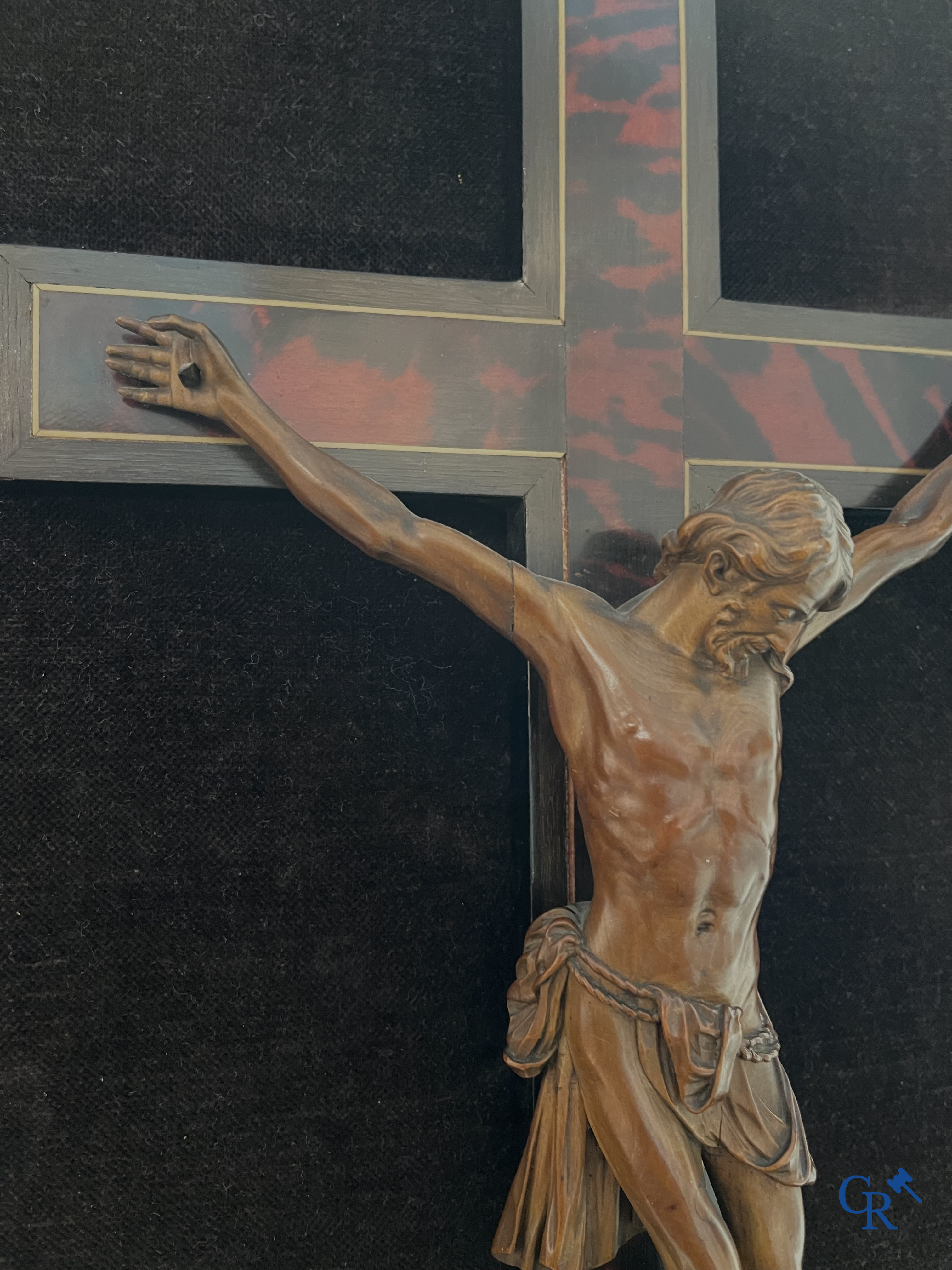 Corpus Christi in fijngesneden palmhout gemonteerd op kruis. Kader van de werkhuizen Franck te Antwerpen. 18e-19e eeuw.