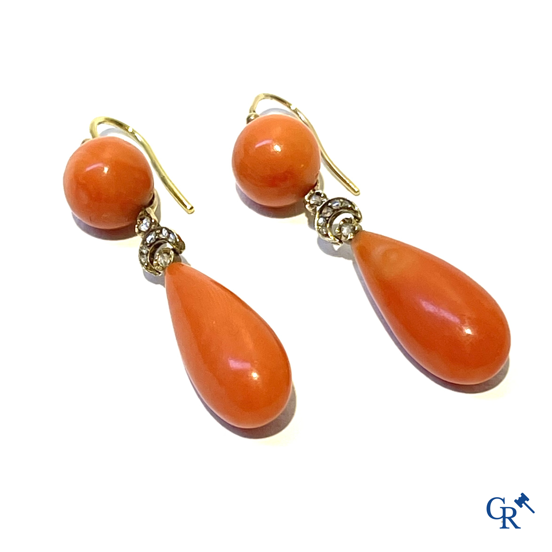 Juwelen. Een paar Art Deco oorringen in geelgoud 750°/00, kleine briljanten en rode koraal.