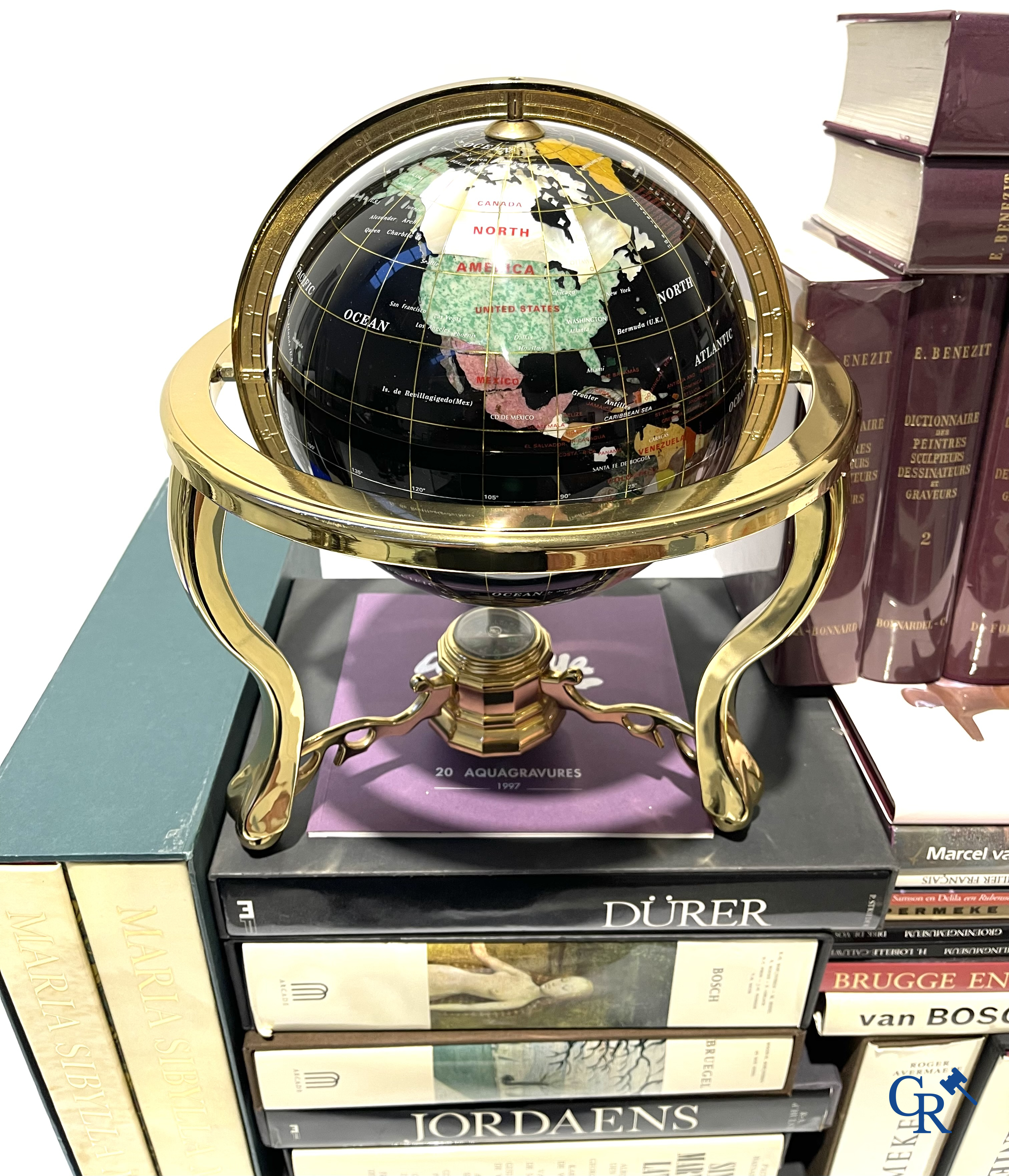 Groot lot kunstboeken, het Bénézit-woordenboek en een decoratieve moderne wereldbol.