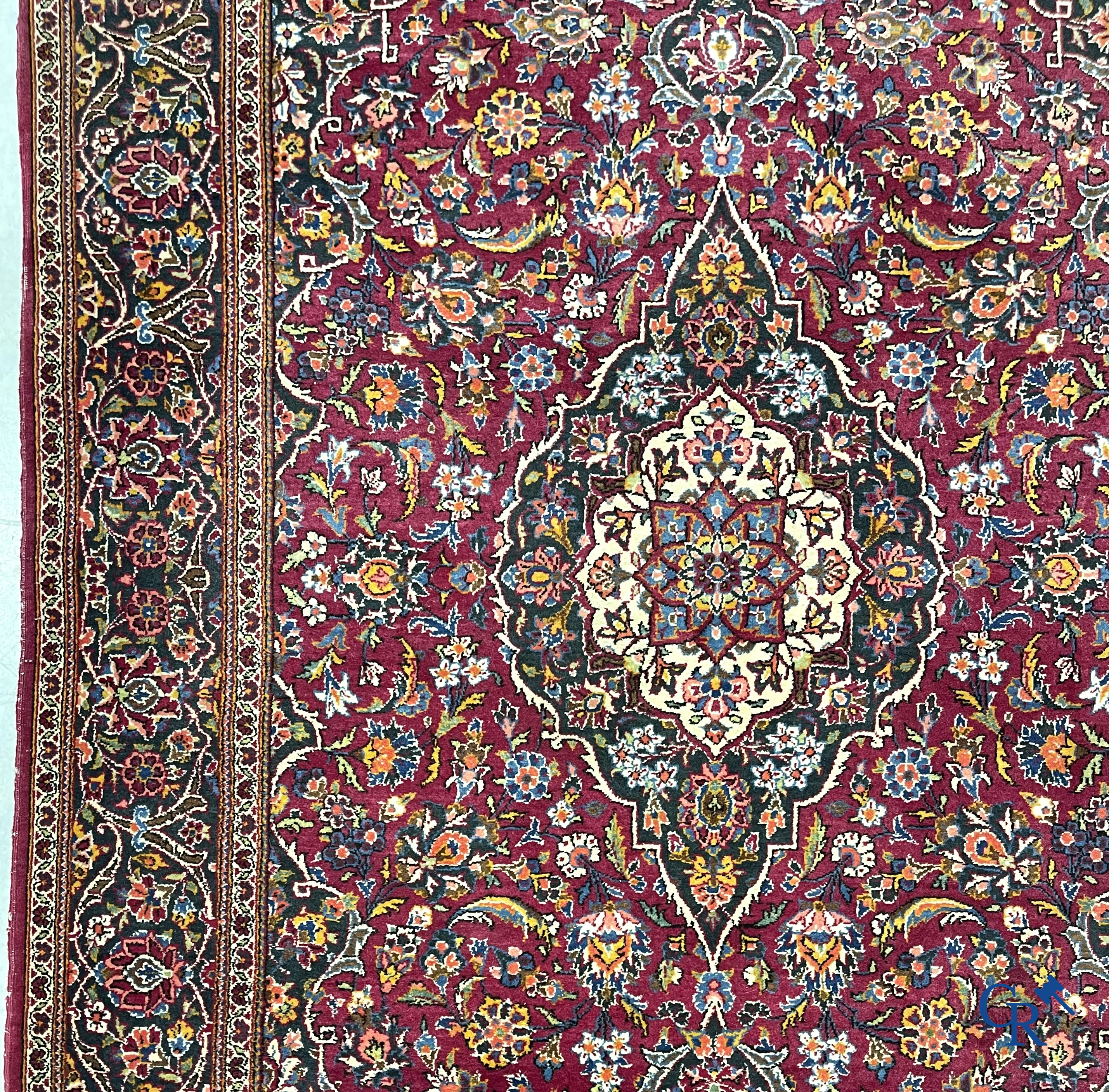 Oosterse tapijten. Een handgeknoopt oosters tapijt met floraal decor op rode achtergrond.