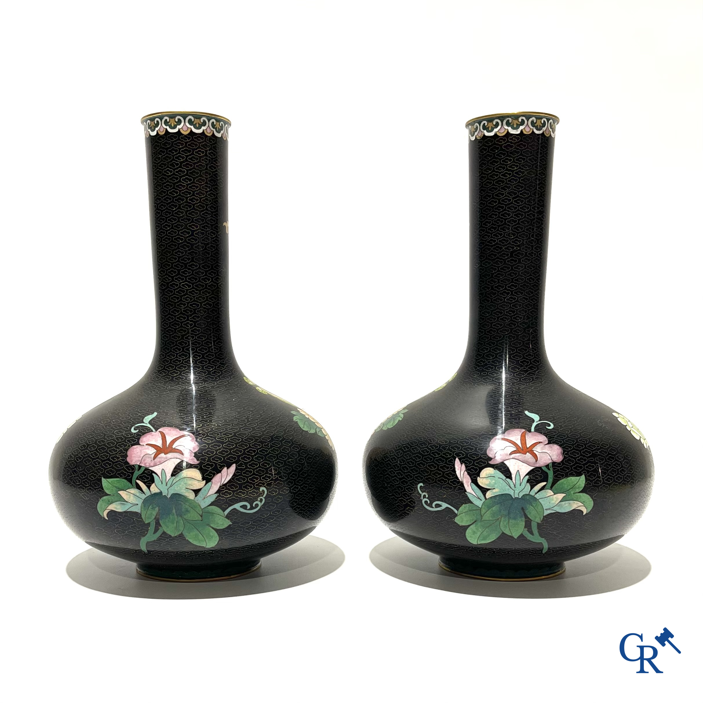 A pair of Chinese cloisonne vases with floral decor.