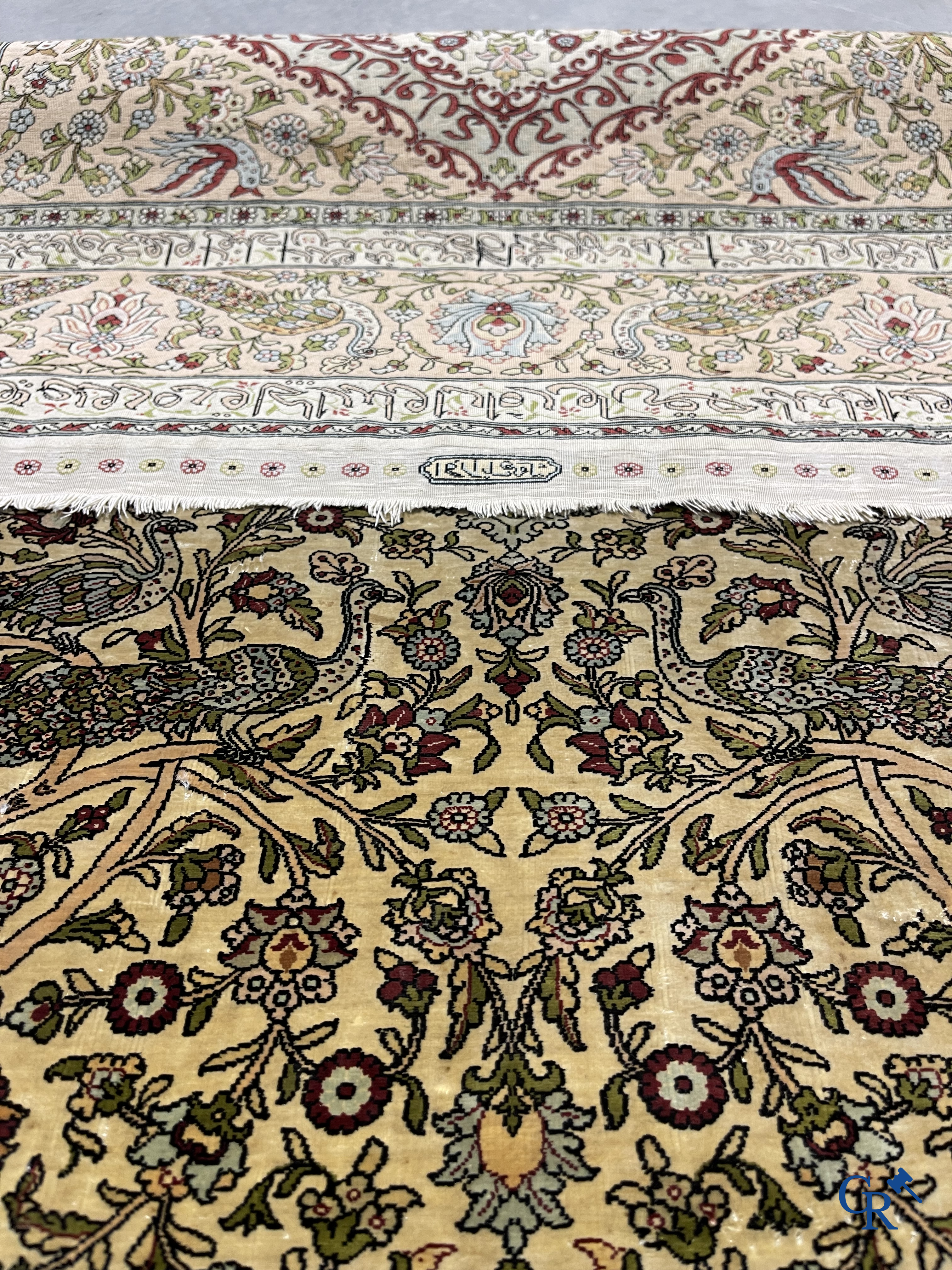 Oriental carpets. Hereke. A finely hand-knotted silk carpet with birds in the forest. Inscriptions and signed.