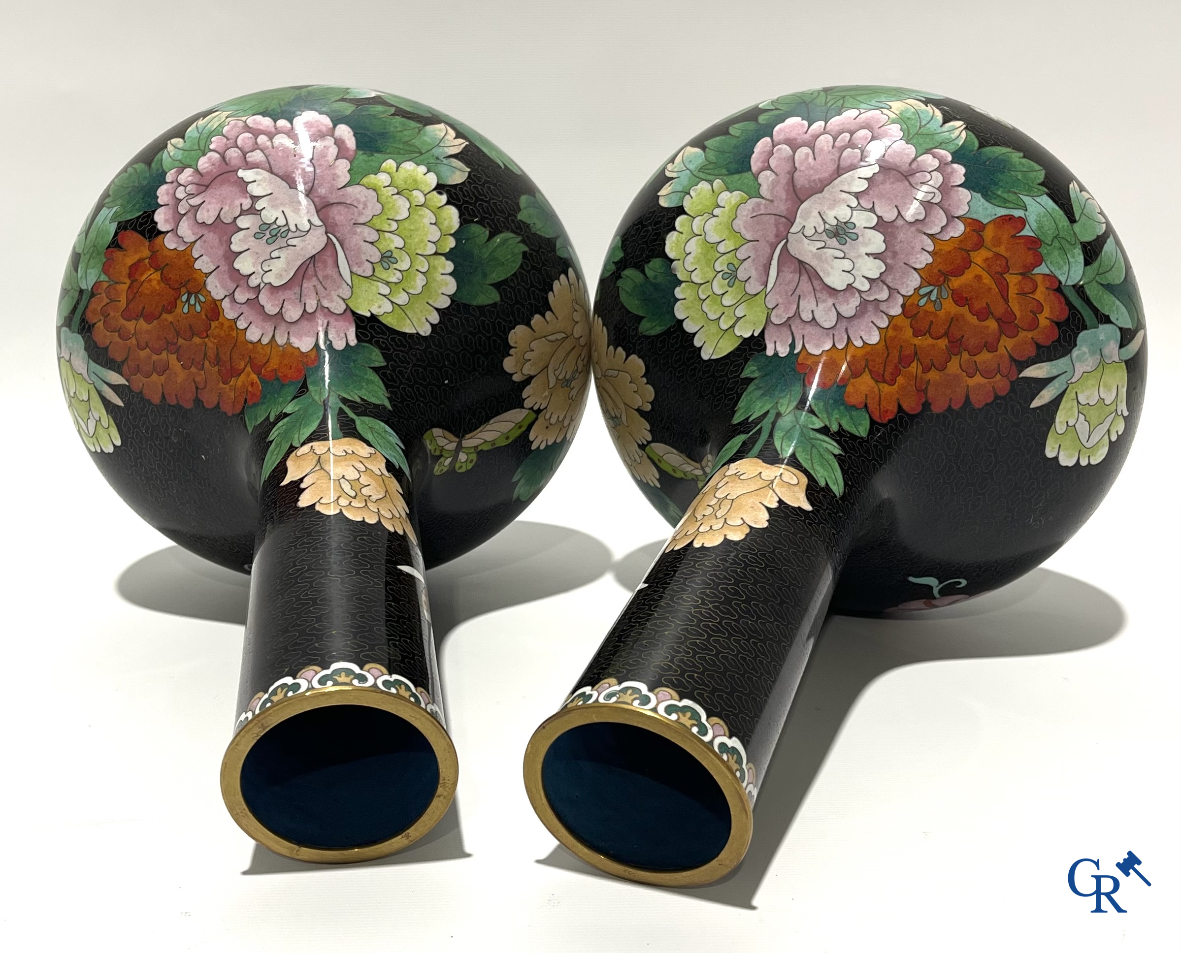 A pair of Chinese cloisonne vases with floral decor.