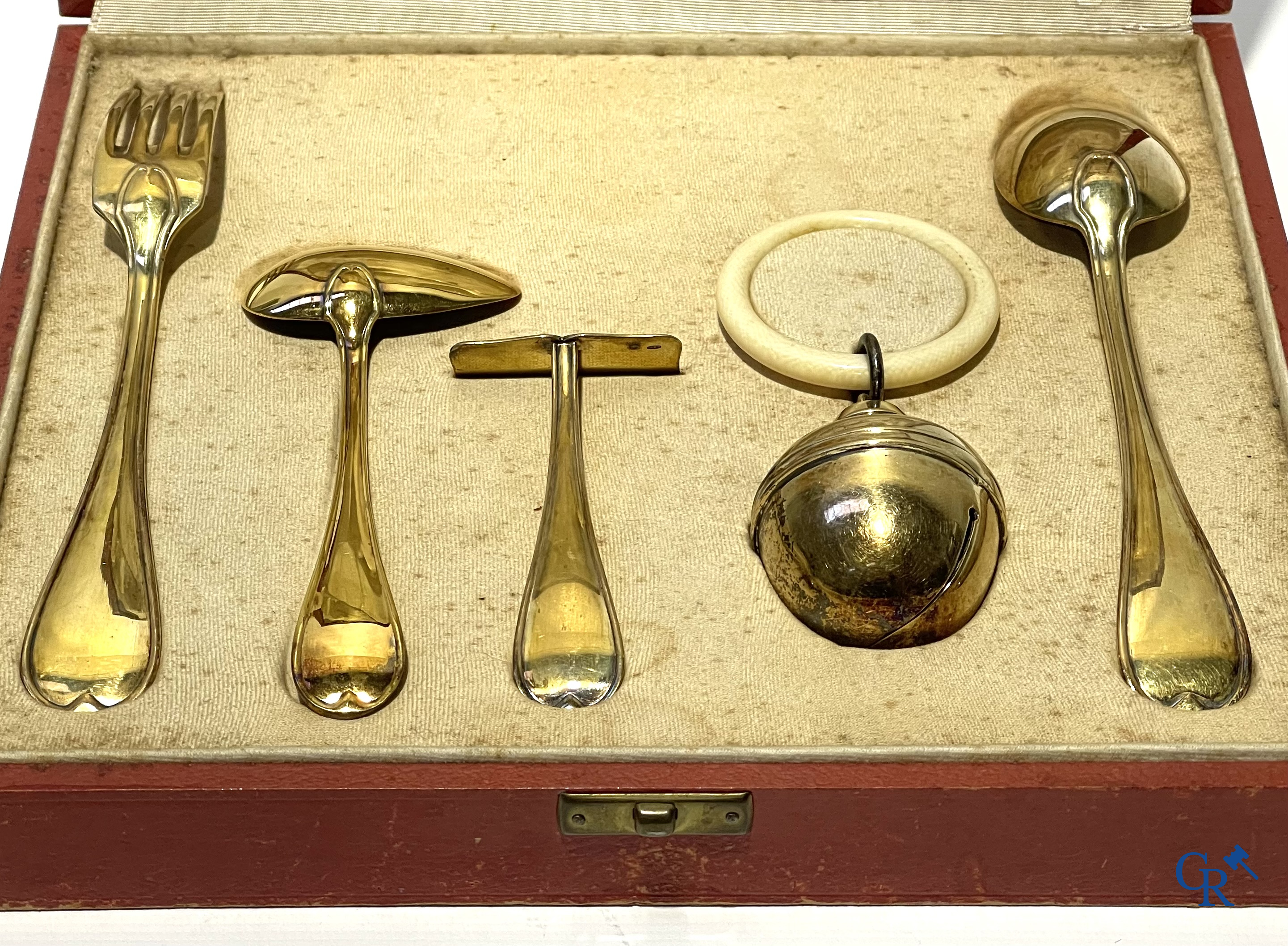 Wolfers Brussel. Geboorteset in vermeil 835°/00, de rammelaar 925°/00 en een set in zilver 835°/00. 20ste eeuw.