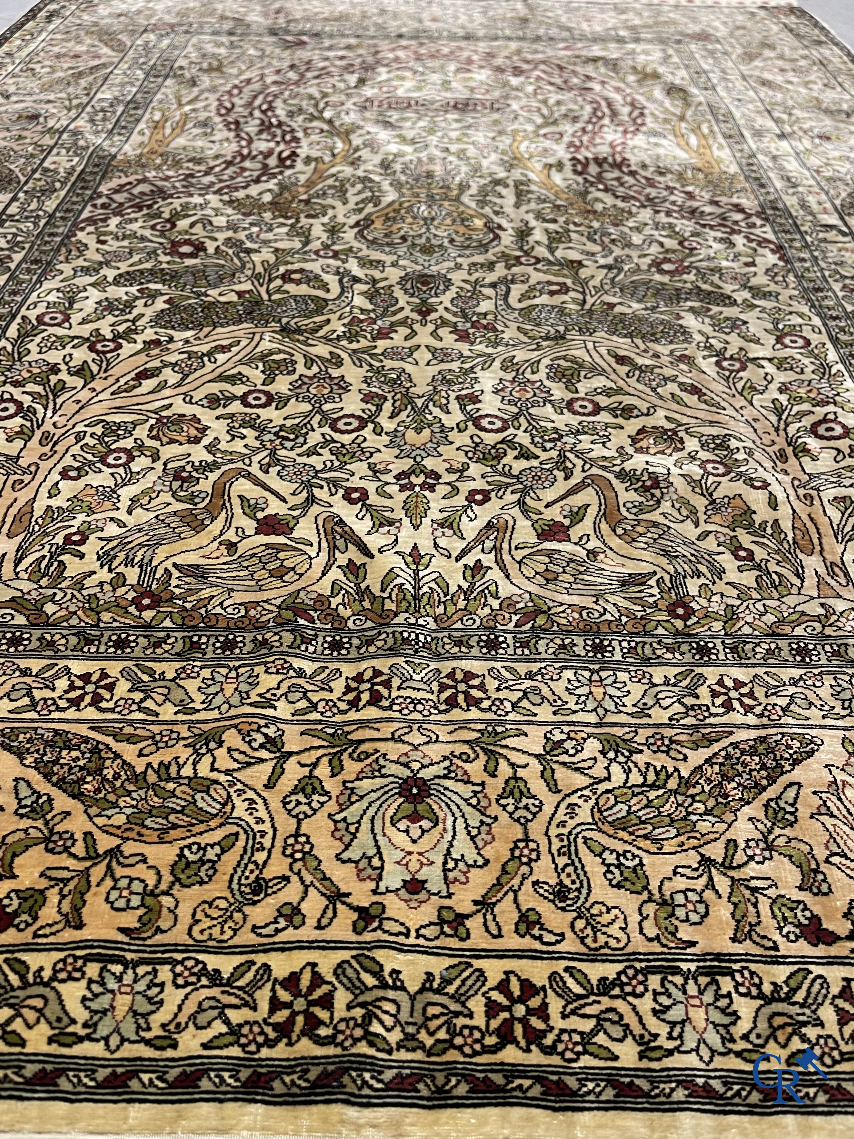 Oriental carpets. Hereke. A finely hand-knotted silk carpet with birds in the forest. Inscriptions and signed.