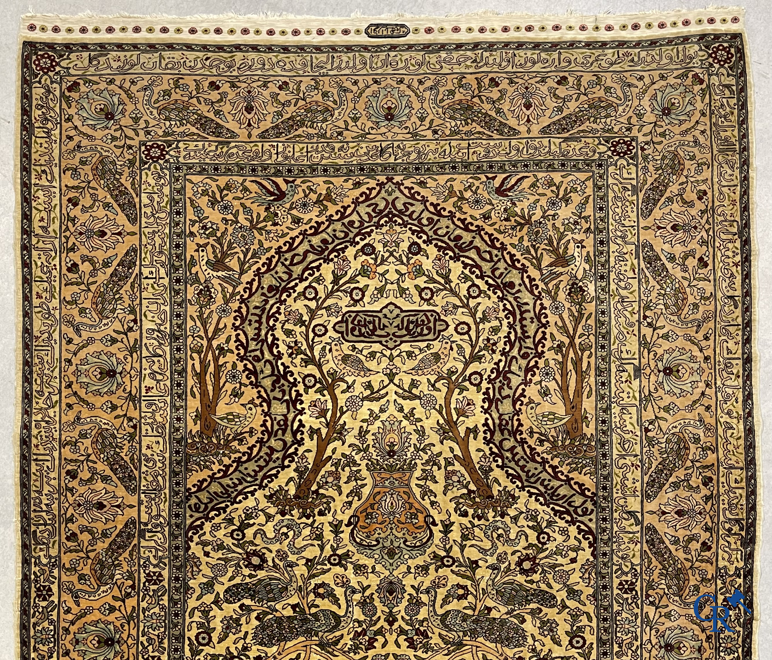 Oriental carpets. Hereke. A finely hand-knotted silk carpet with birds in the forest. Inscriptions and signed.
