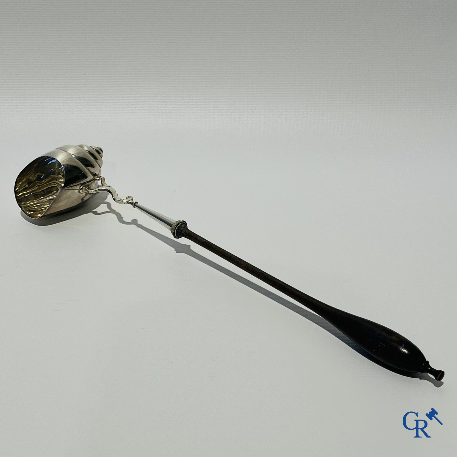 Zilveren punchlepel in de vorm van een slakkenhuis met houten steel.  Zilver 1ste gehalte. Meerdere keurmerken.