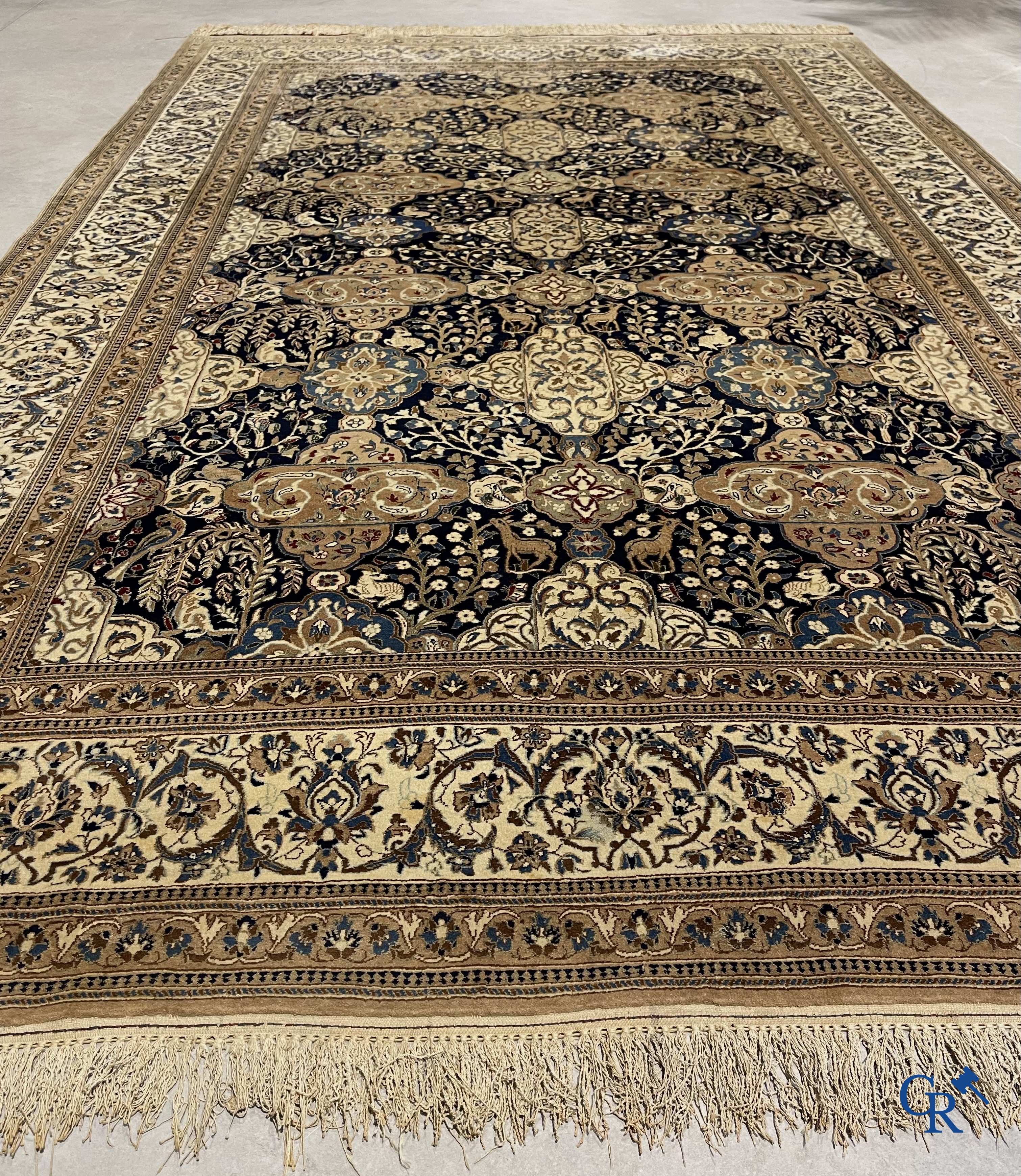 Oosterse tapijten. Een handgeknoopt tapijt met wouddieren en bloemen.