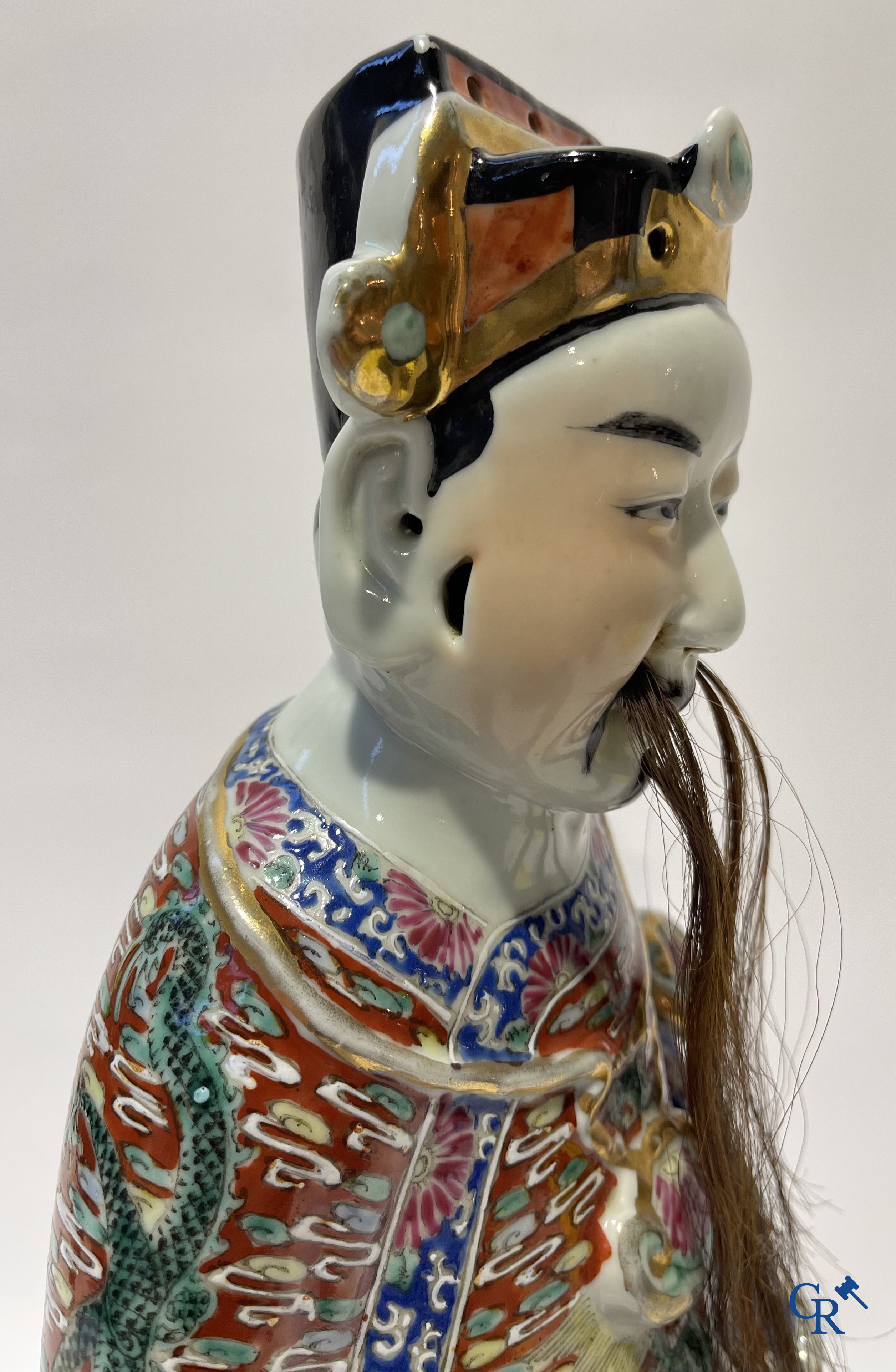 Aziatica. Een Chinese wijsheer in famille rose porselein op een houten sokkel. Gemerkt. 19de eeuw.