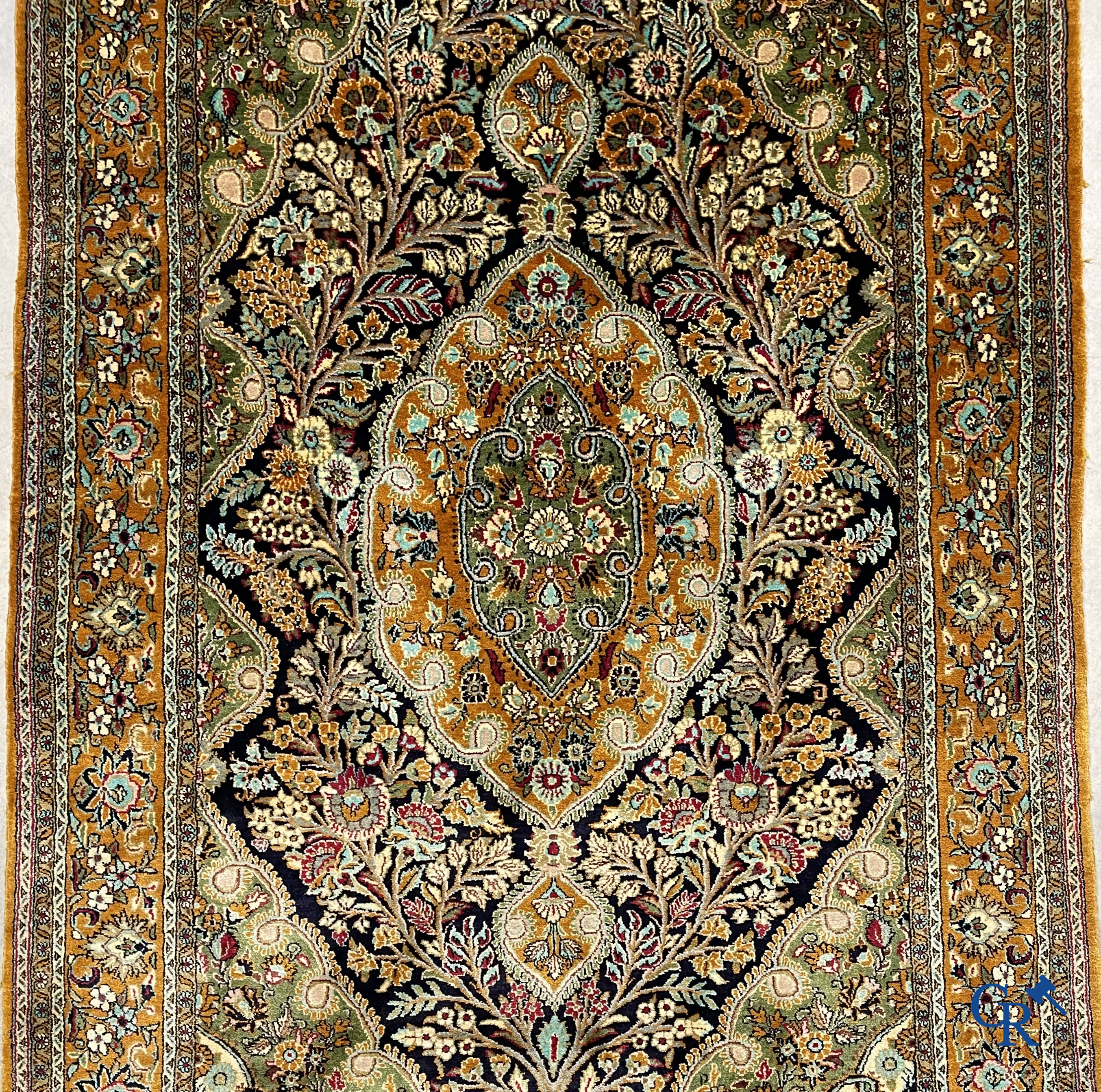 Oriental carpets. Hand-knotted silk carpet with floral decor on an orange background.