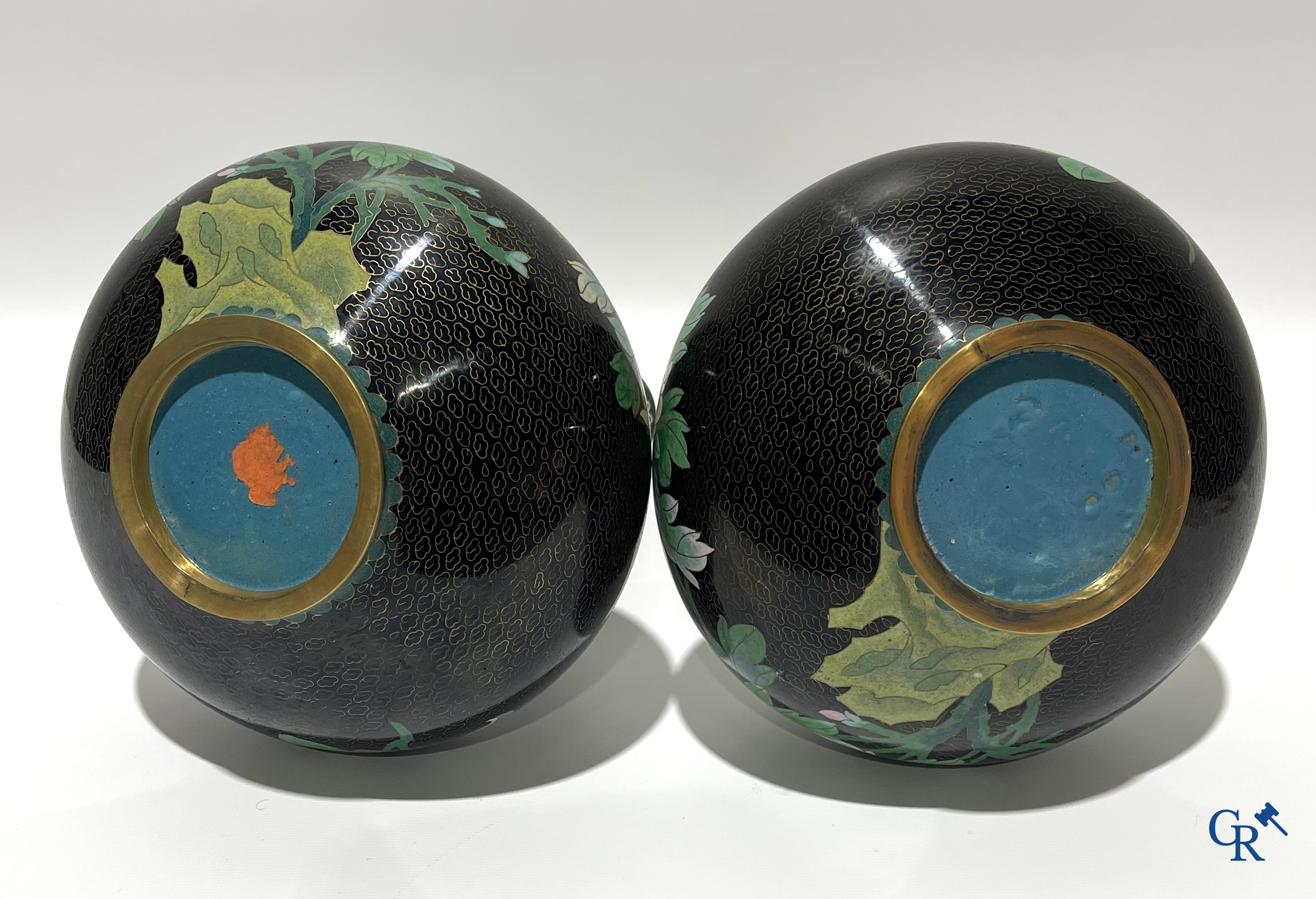 A pair of Chinese cloisonne vases with floral decor.