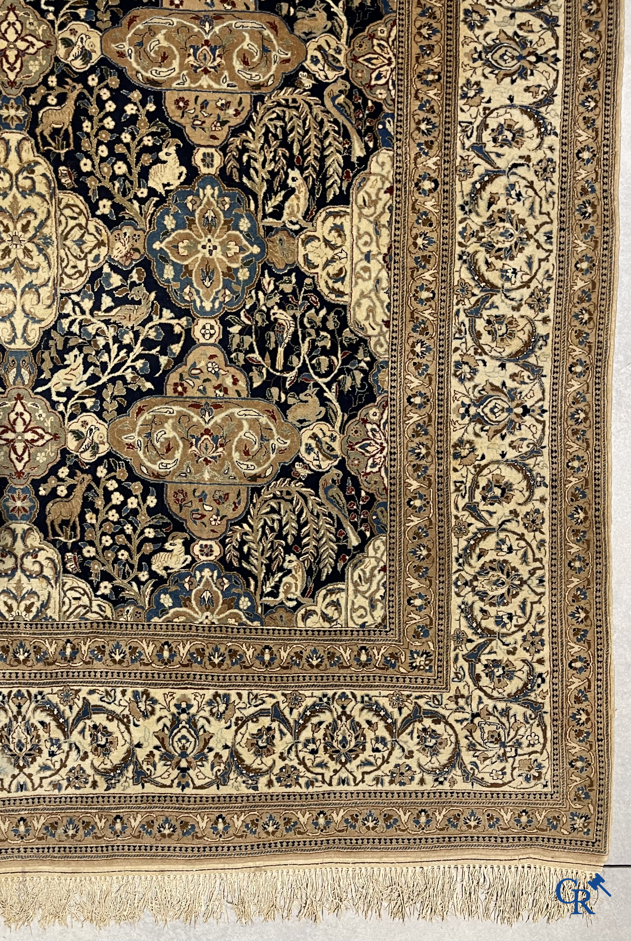 Oosterse tapijten. Een handgeknoopt tapijt met wouddieren en bloemen.