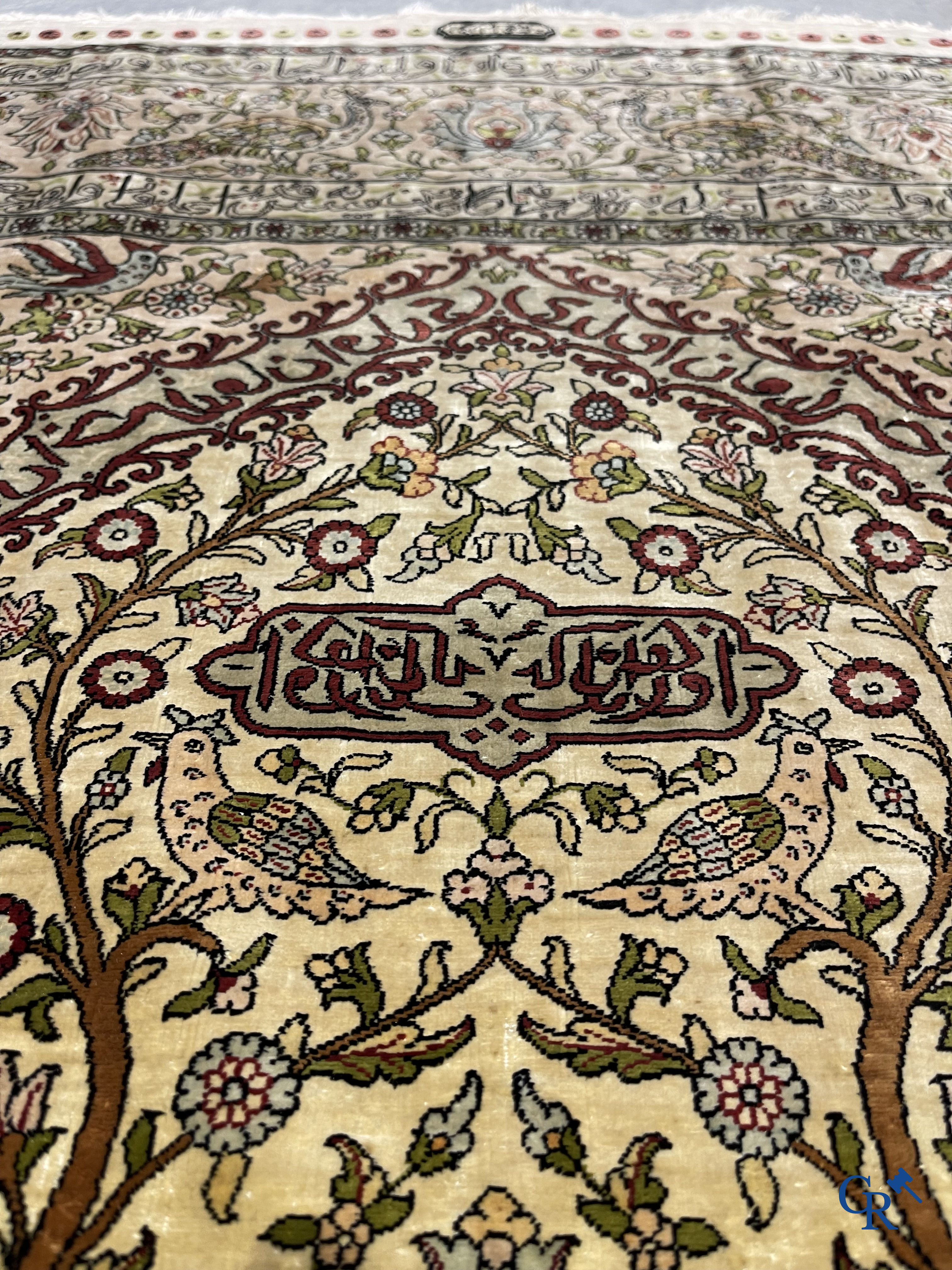 Oriental carpets. Hereke. A finely hand-knotted silk carpet with birds in the forest. Inscriptions and signed.
