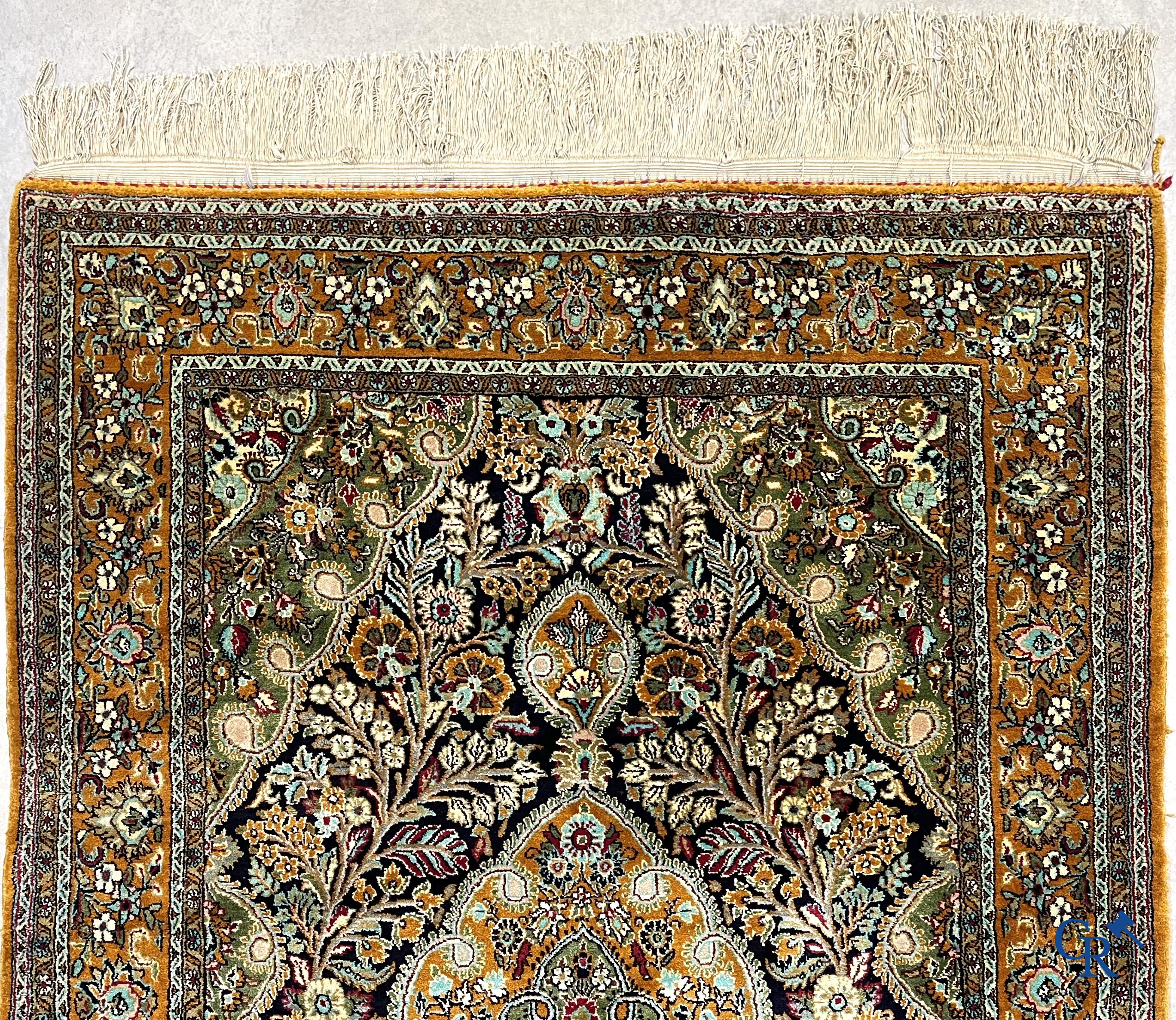 Oriental carpets. Hand-knotted silk carpet with floral decor on an orange background.