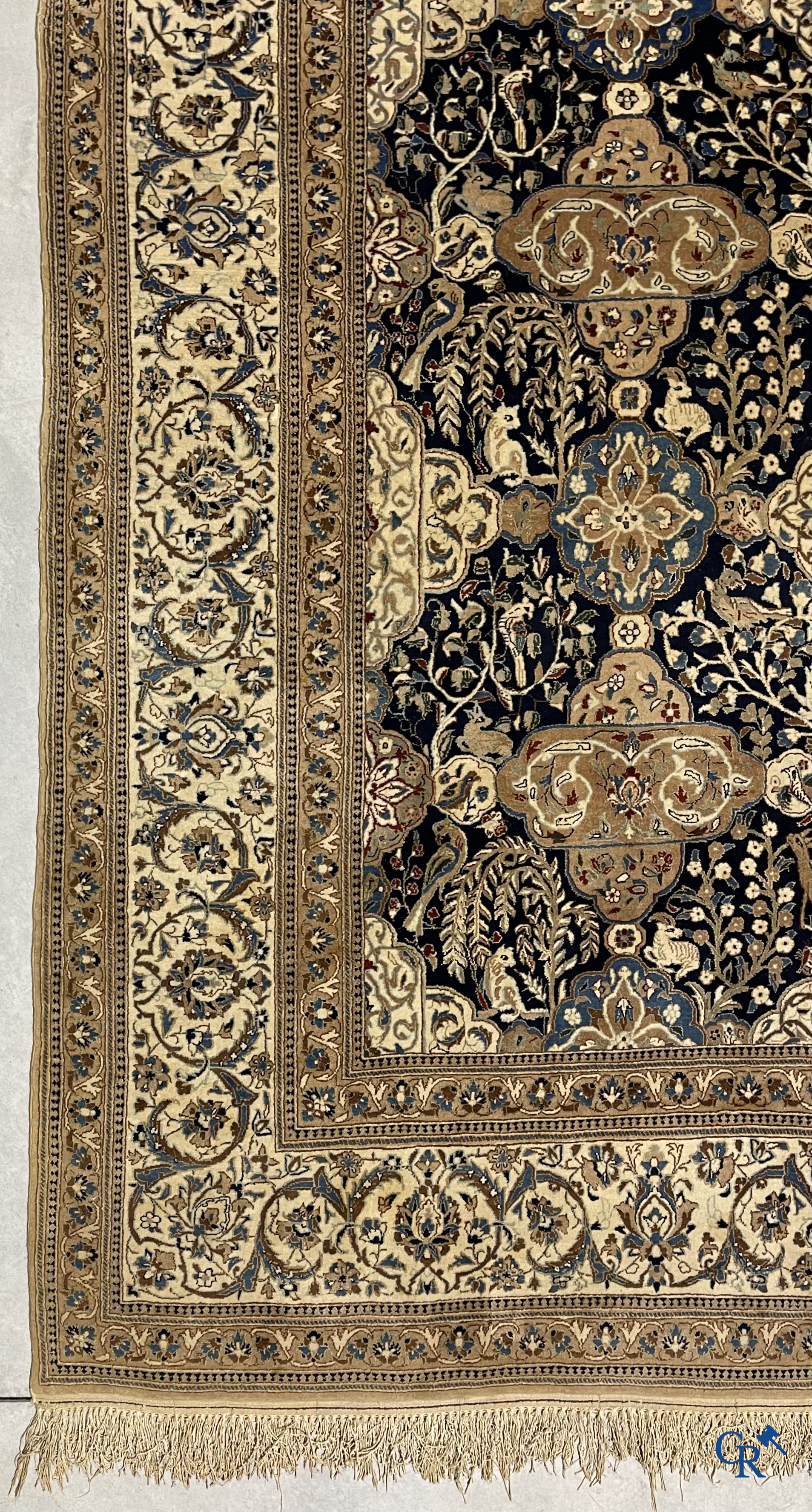 Oosterse tapijten. Een handgeknoopt tapijt met wouddieren en bloemen.