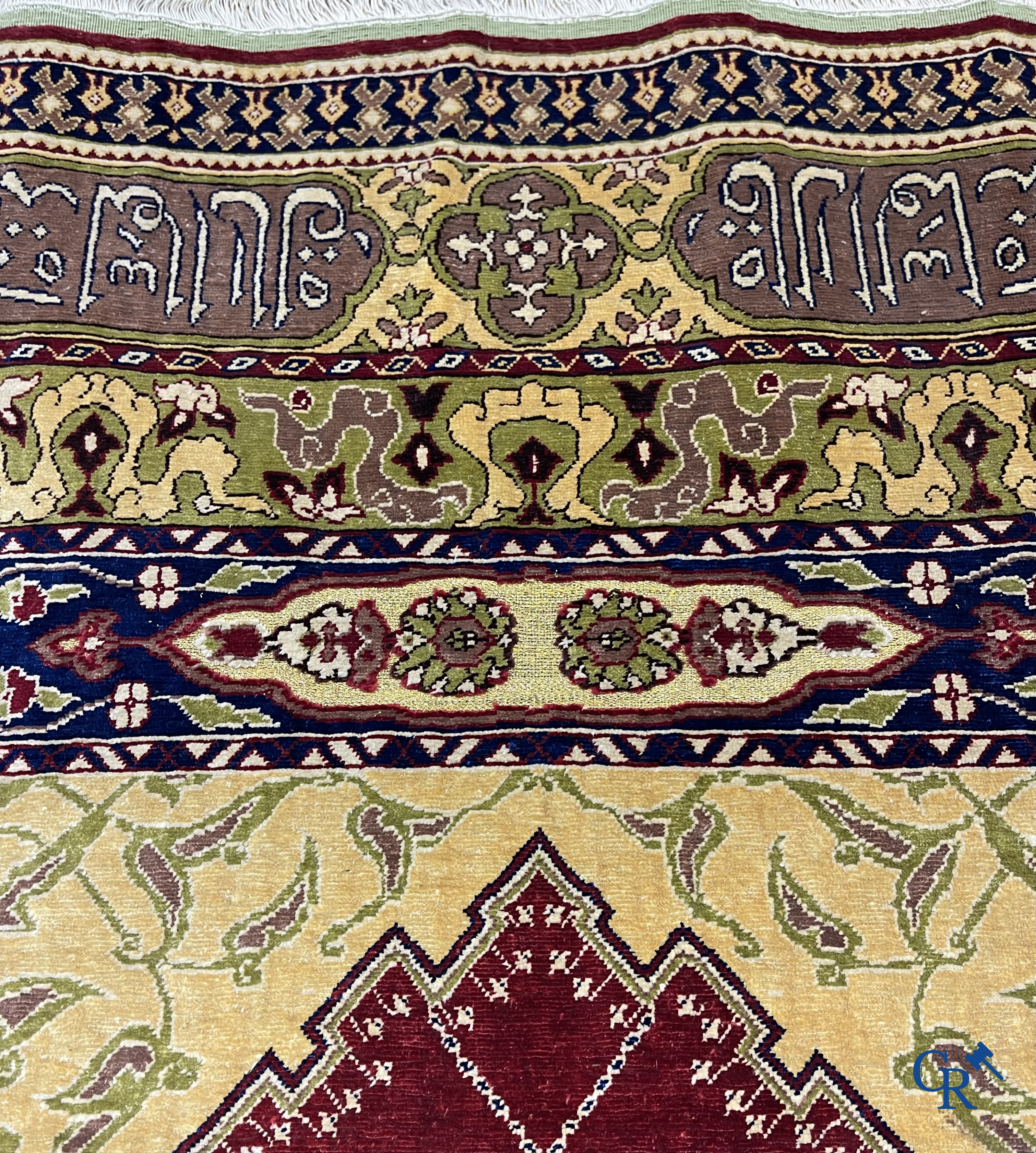 Oosterse tapijten. Een uiterst fijn handgeknoopt zijden tapijt met inscripties en gouddraad. Gesigneerd.