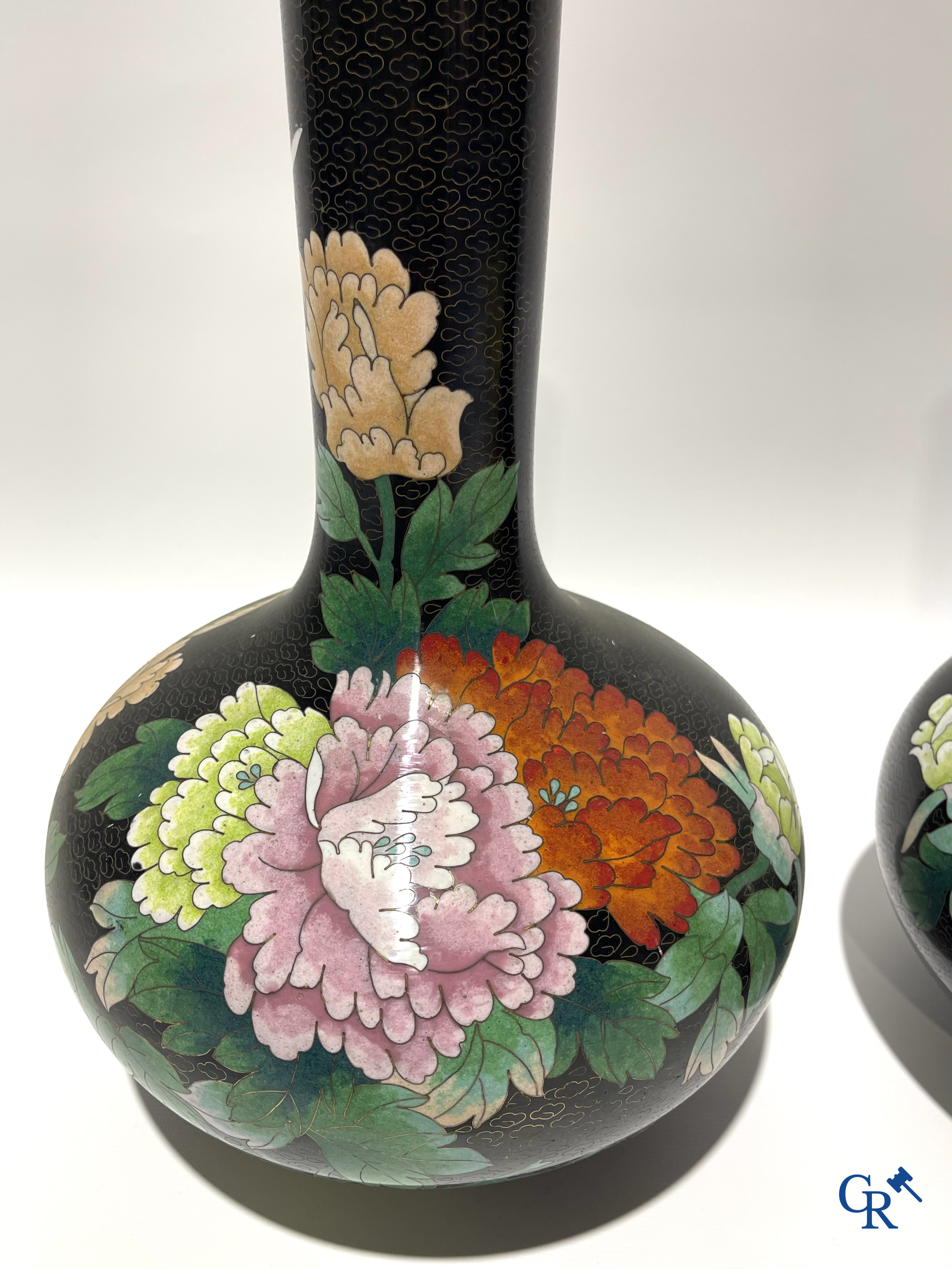 A pair of Chinese cloisonne vases with floral decor.