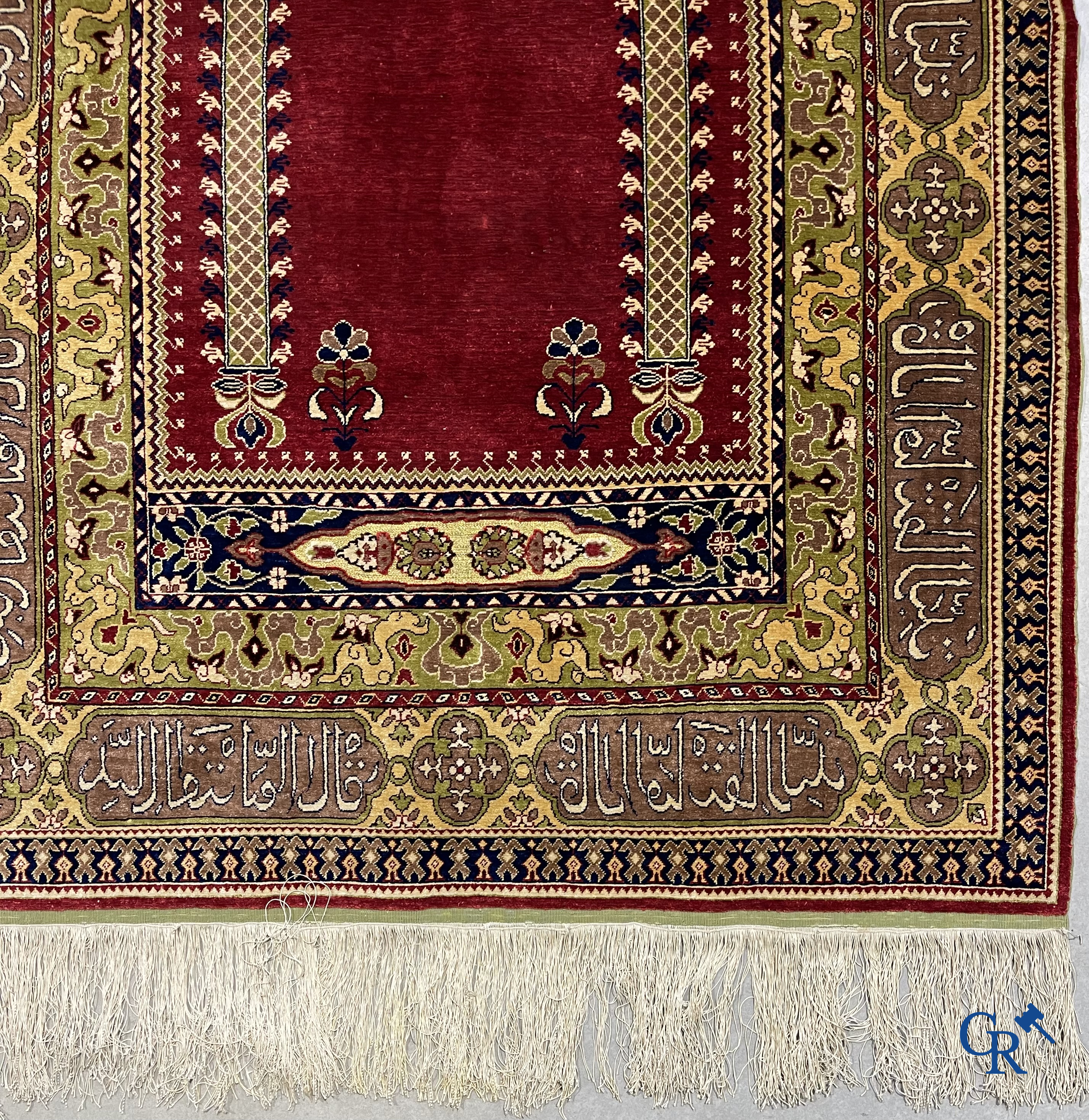 Oosterse tapijten. Een uiterst fijn handgeknoopt zijden tapijt met inscripties en gouddraad. Gesigneerd.