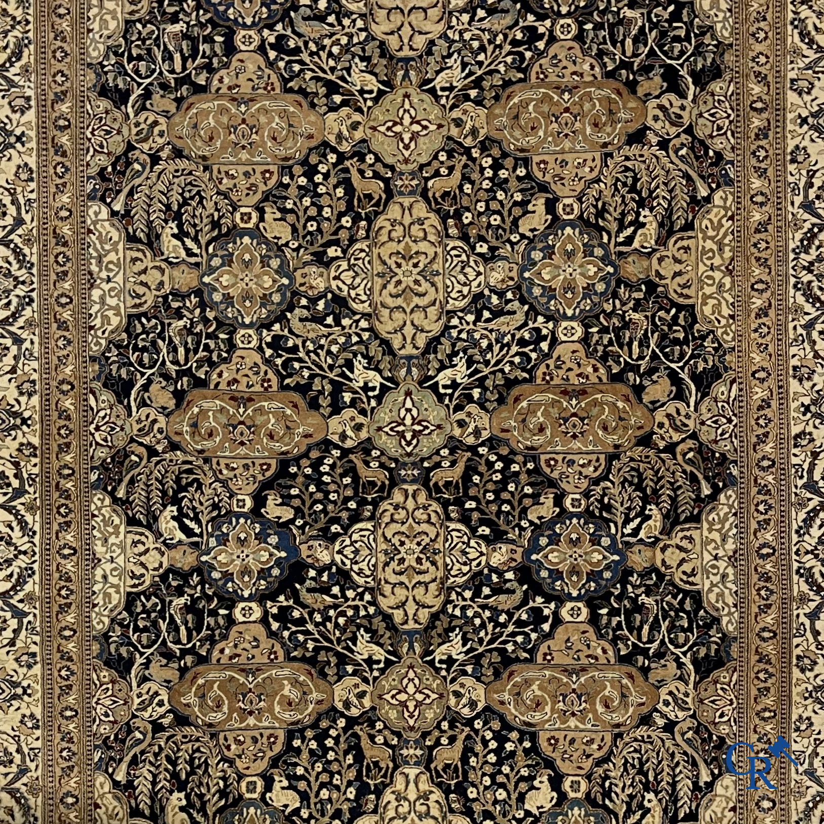 Oosterse tapijten. Een handgeknoopt tapijt met wouddieren en bloemen.